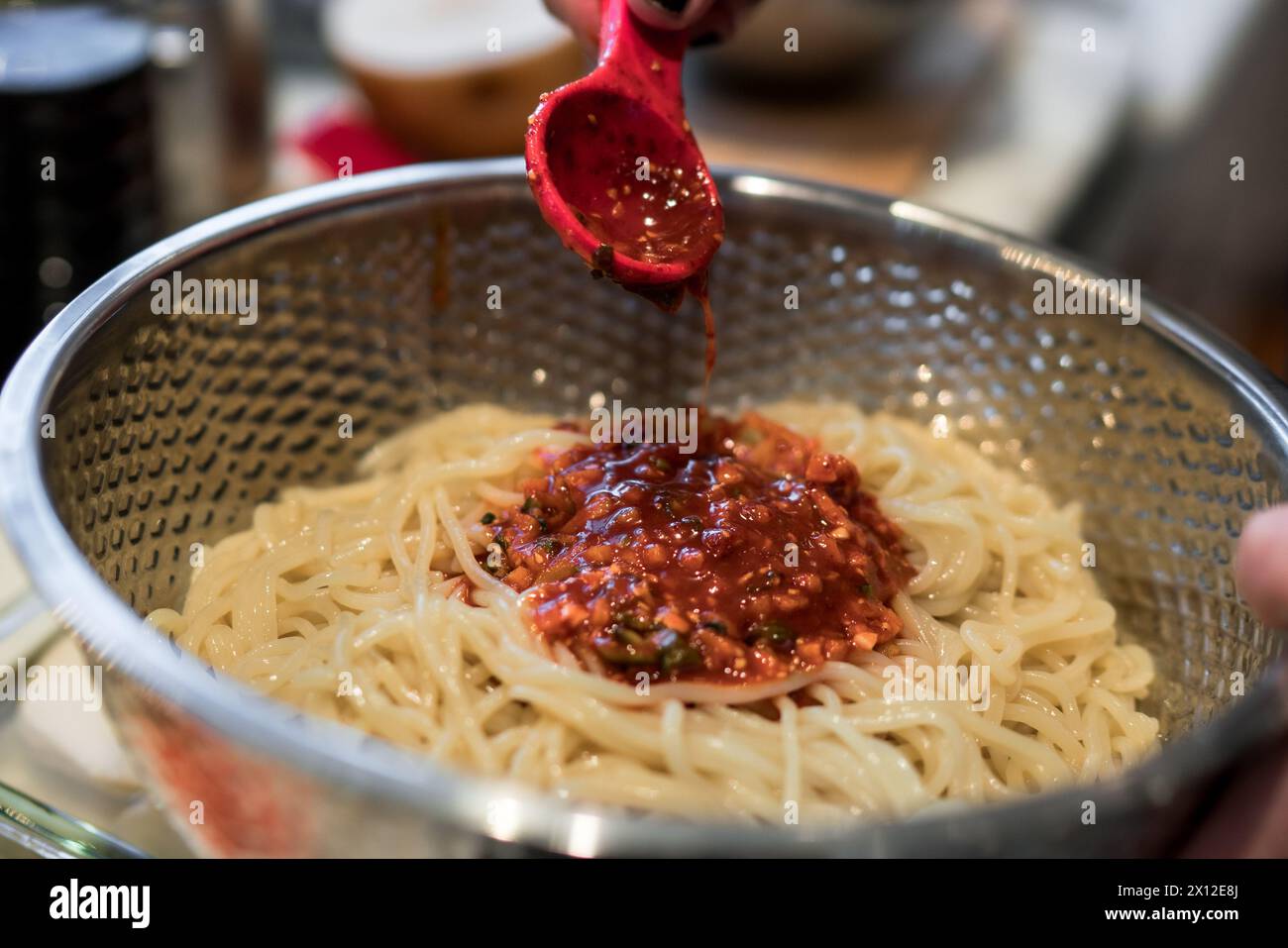 Aggiunta della salsa Gochujang ai tagliatelle fredde Foto Stock