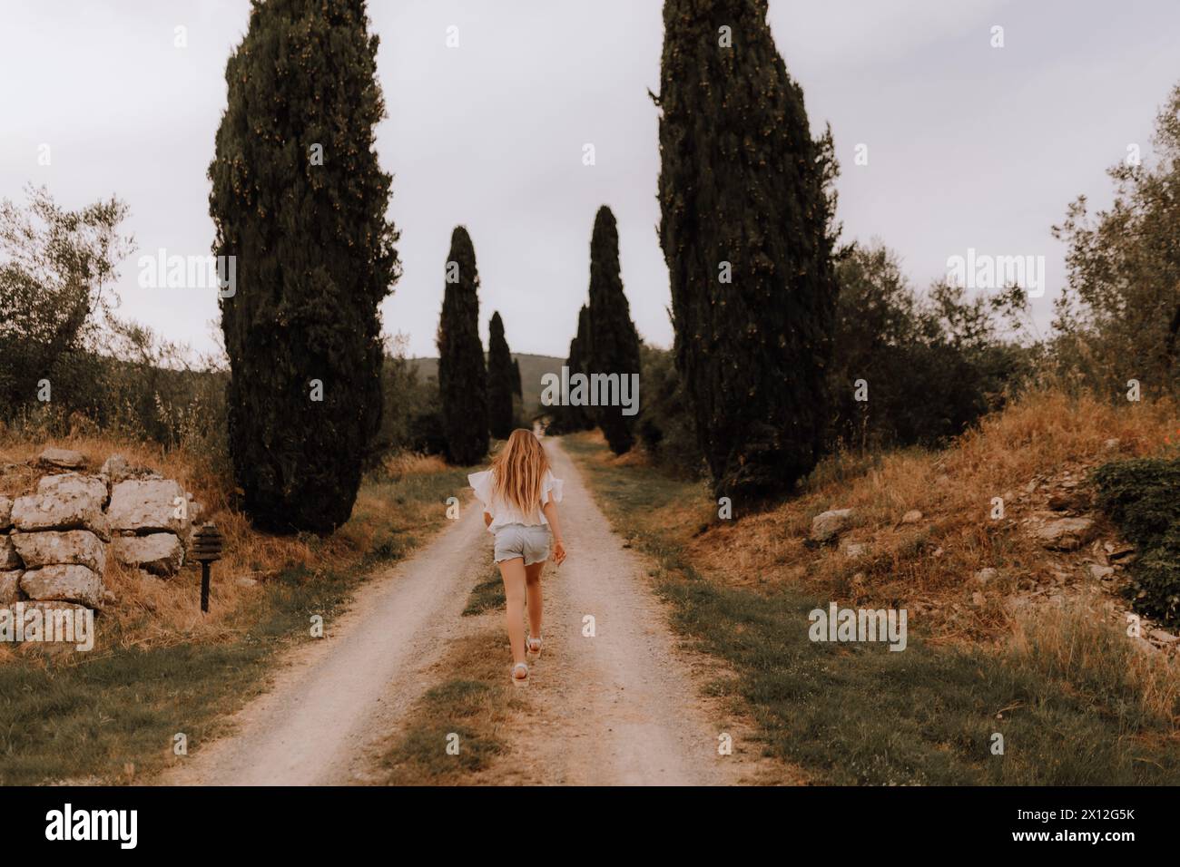 Esplorando la Toscana: Adolescente con cappello su Cypress Hill Foto Stock