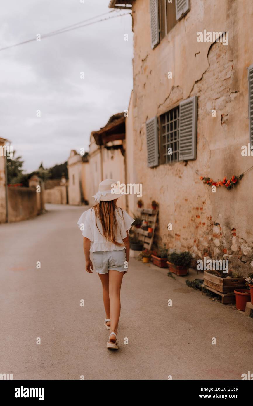 Adolescente con cappello che esplora la città di campagna italiana Foto Stock