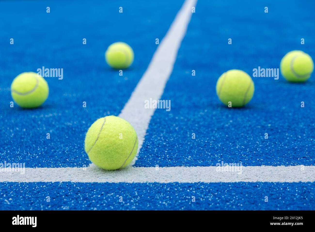 cinque palline in un campo da paddle tennis blu Foto Stock