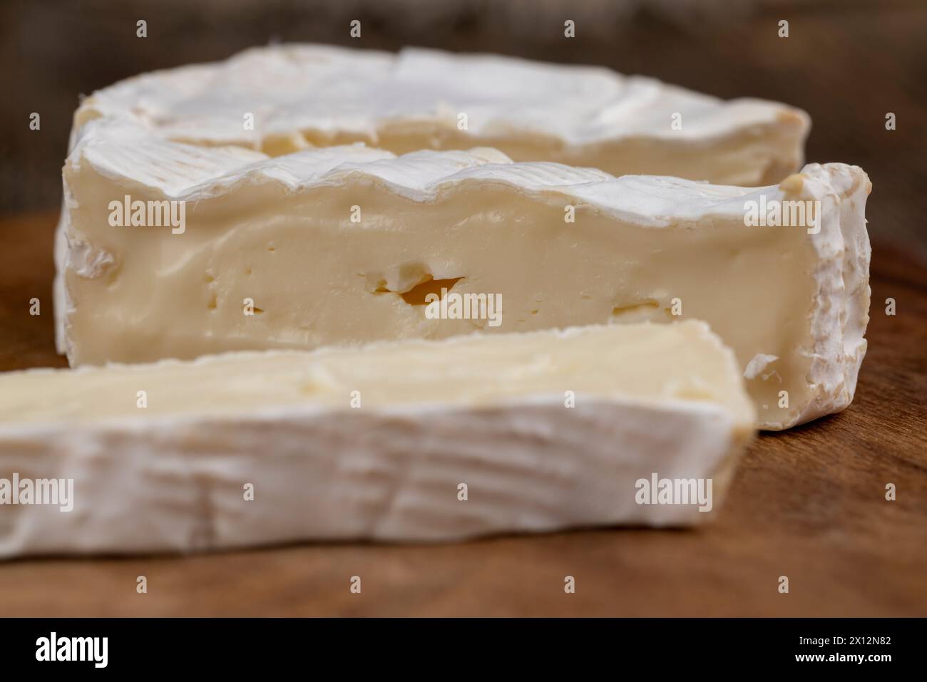 formaggio morbido lavorato con muffa bianca sul tavolo, formaggio bianco a fette con primo piano di muffa Foto Stock