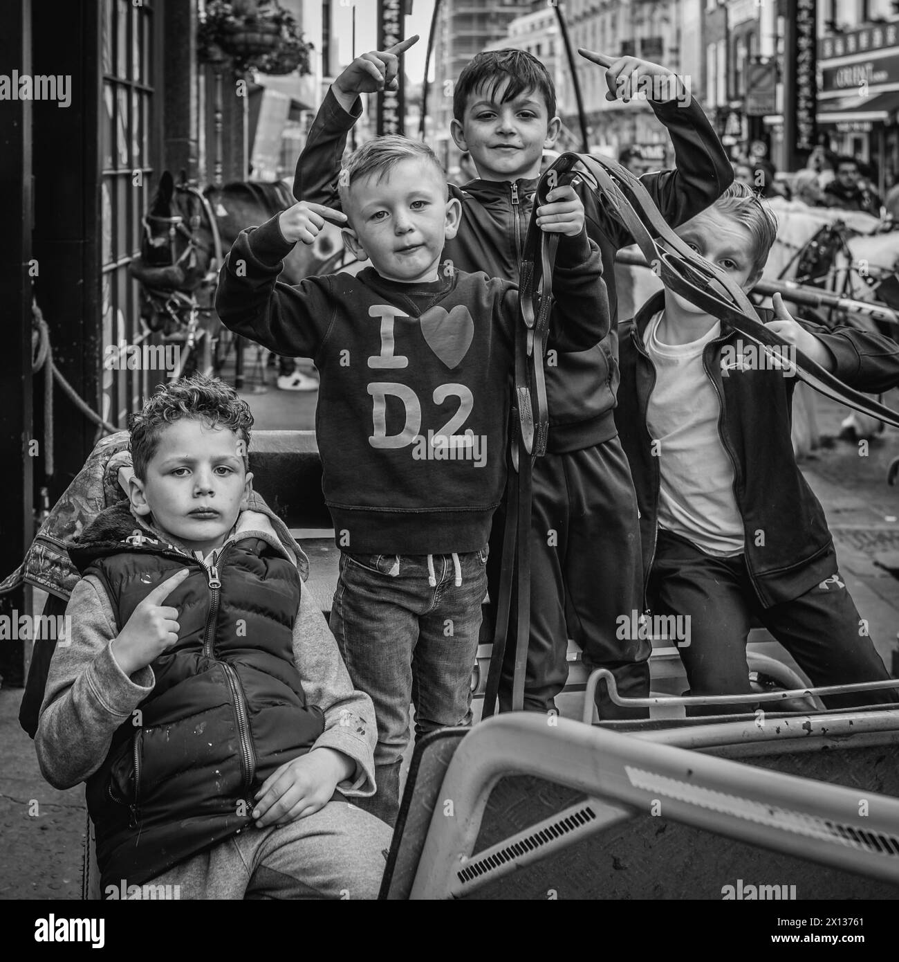 Immagine in bianco e nero di giovani rom e viaggiatori in posa in un carretto da cavalli mentre viaggiano attraverso Chinatown per l'evento "The London Drive". Foto Stock