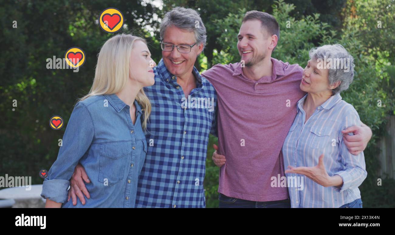 Immagine di icone di cuori che falliscono sopra la famiglia caucasica all'esterno Foto Stock
