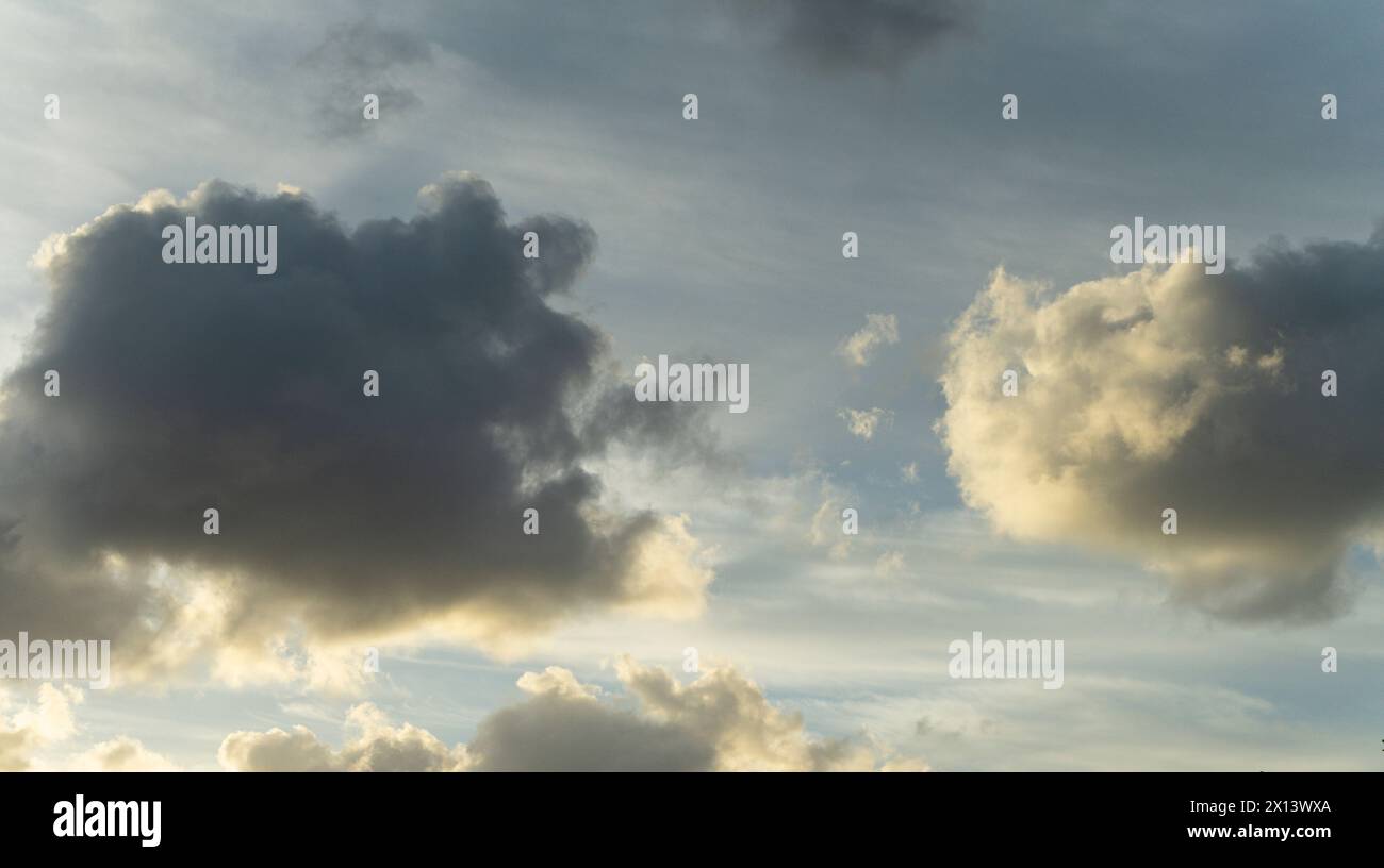 Un cielo tranquillo con morbide nuvole arancioni su uno sfondo blu chiaro. schermata verticale sfondo trattativa Foto Stock