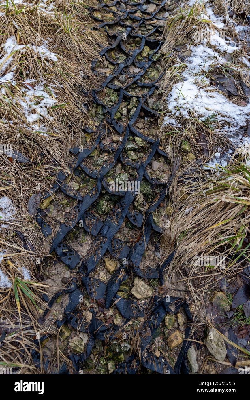 rete in plastica nera per rinforzo di terra, geogriglia in plastica sulla riva del fiume in collina Foto Stock