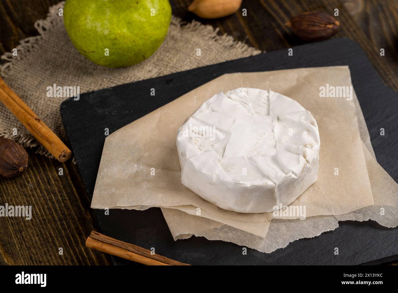 formaggio rotondo bianco con muffa sul tavolo, formaggio fresco morbido con muffa bianca nobile che si può mangiare Foto Stock