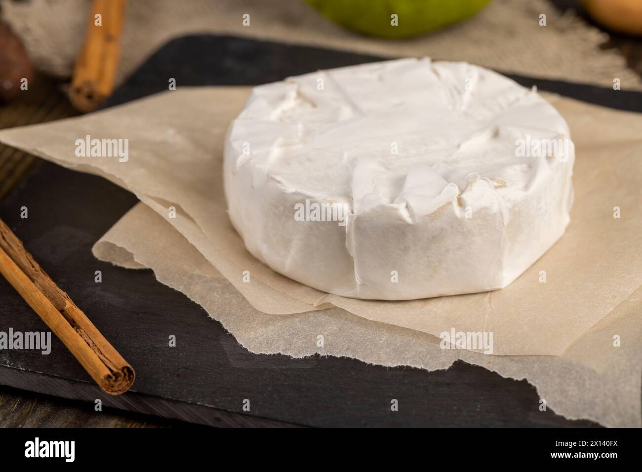 formaggio rotondo bianco con muffa sul tavolo, formaggio fresco morbido con muffa bianca nobile che si può mangiare Foto Stock