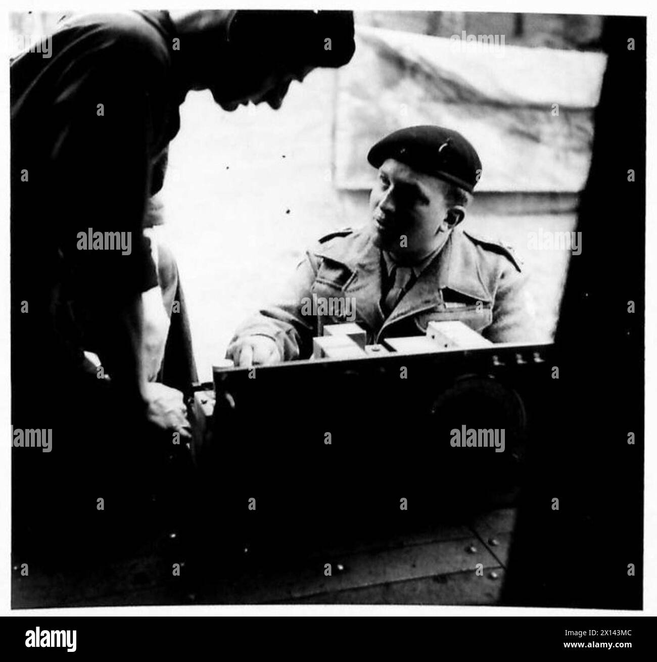 Il capitano D.J. Owen, MBE, ufficiale responsabile dei segnali, parla di riparazione wireless con Instrument Mechanic Sgmn. Deakin nell'esercito britannico, ventunesimo gruppo d'armate. Foto Stock