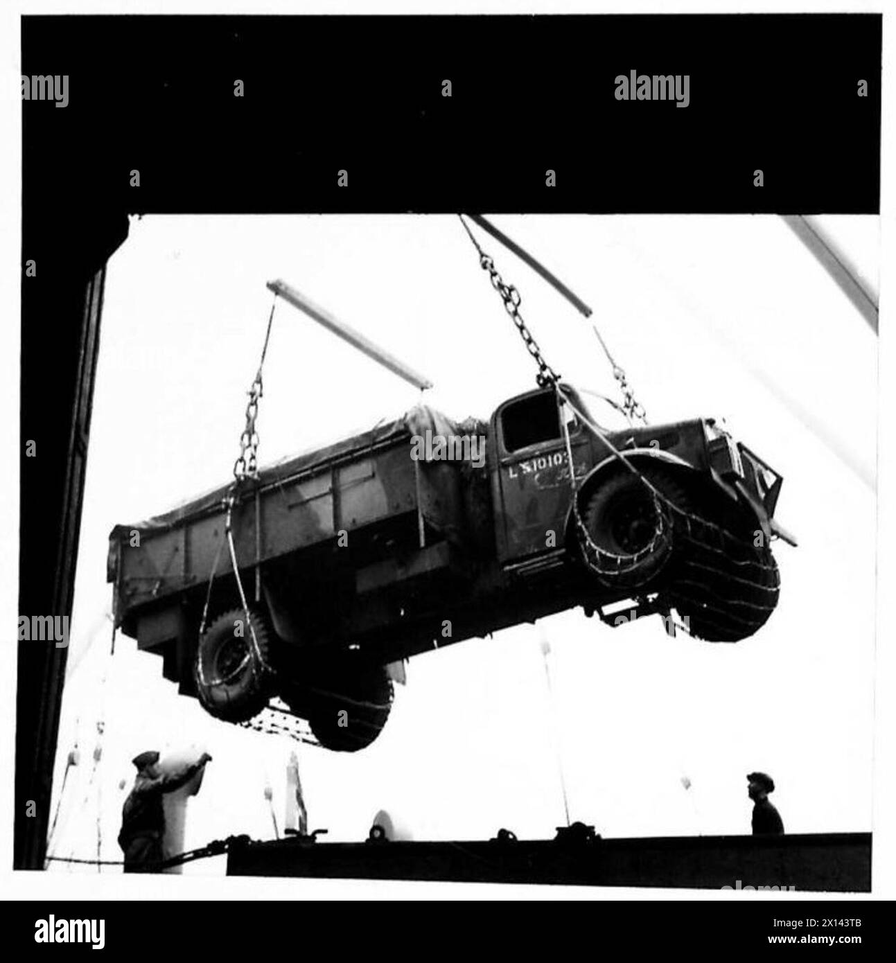 Le truppe britanniche e americane si imbarcano come un camion viene trasferito dalla banchina a una nave durante le operazioni dell'esercito. Foto Stock