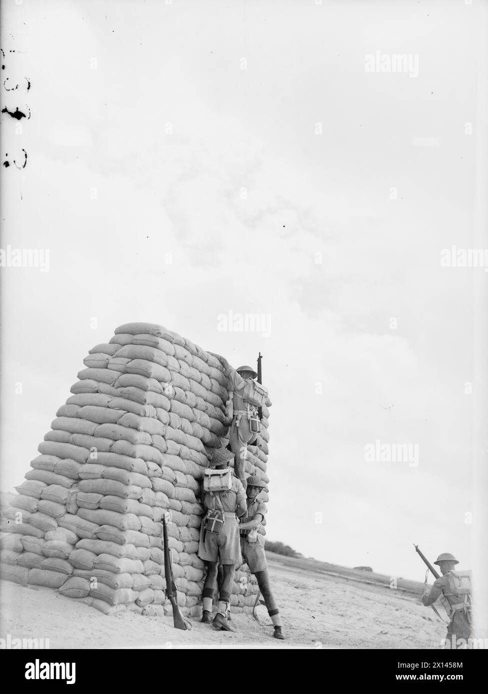 Nel settembre 1943 a Ceylon, il personale della Royal Marine Group Mobile Naval base Defence si allena all'11th Battalion Battlecourse, attraversando ostacoli e praticando il lavoro di squadra sotto fuoco simulato e fumo. Foto Stock