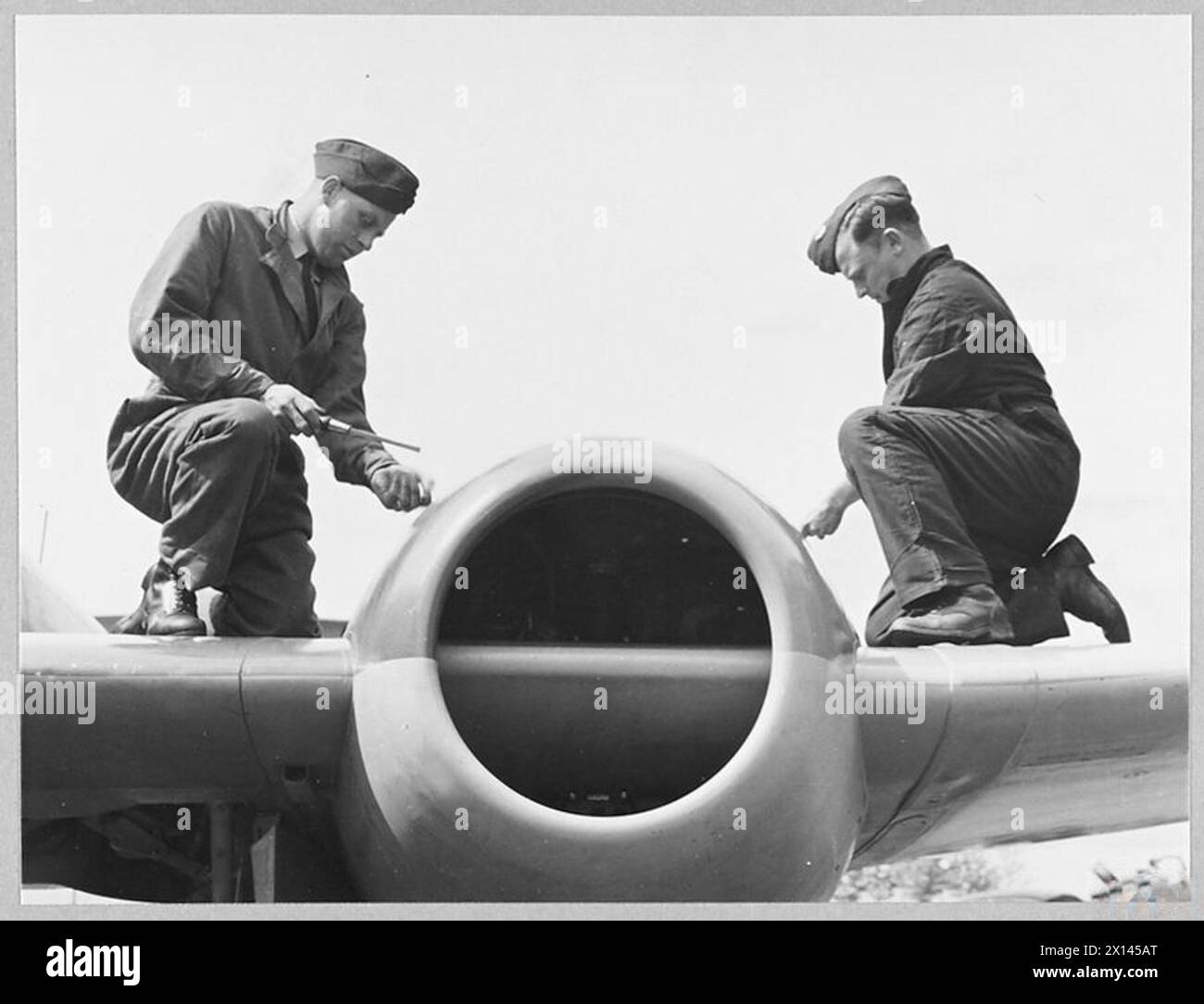 I meccanici di R.A.F. sono mostrati nel 1945 mentre lavorano sull'unità di potenza di un aereo a reazione Meteor in una stazione aerea. Foto Stock