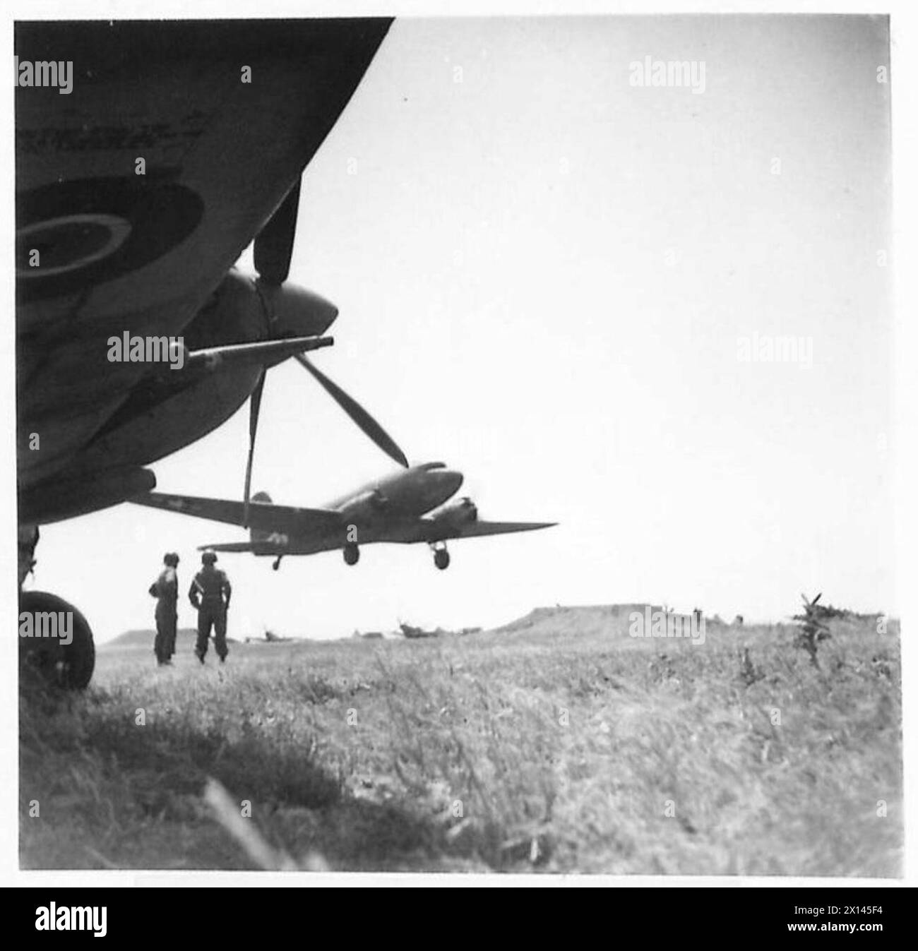 Un aereo Douglas carico decolla mentre i caccia Spitfire sono visibili in primo piano durante le operazioni della Quinta Armata. Foto Stock