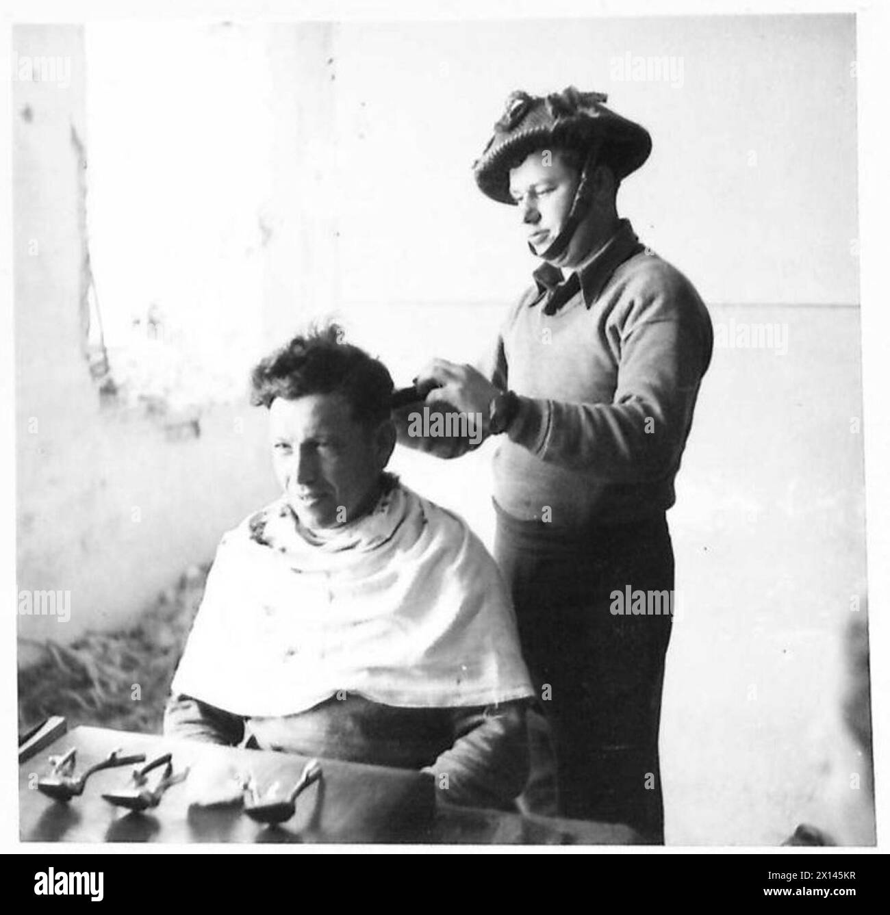 P. Galperin, parrucchiere del i battaglione, taglia i capelli del soldato J. Tanai presso la stazione provvisoria di Mezzano, tra Mezzano e Alfonsine, sotto le operazioni dell'esercito britannico. Foto Stock