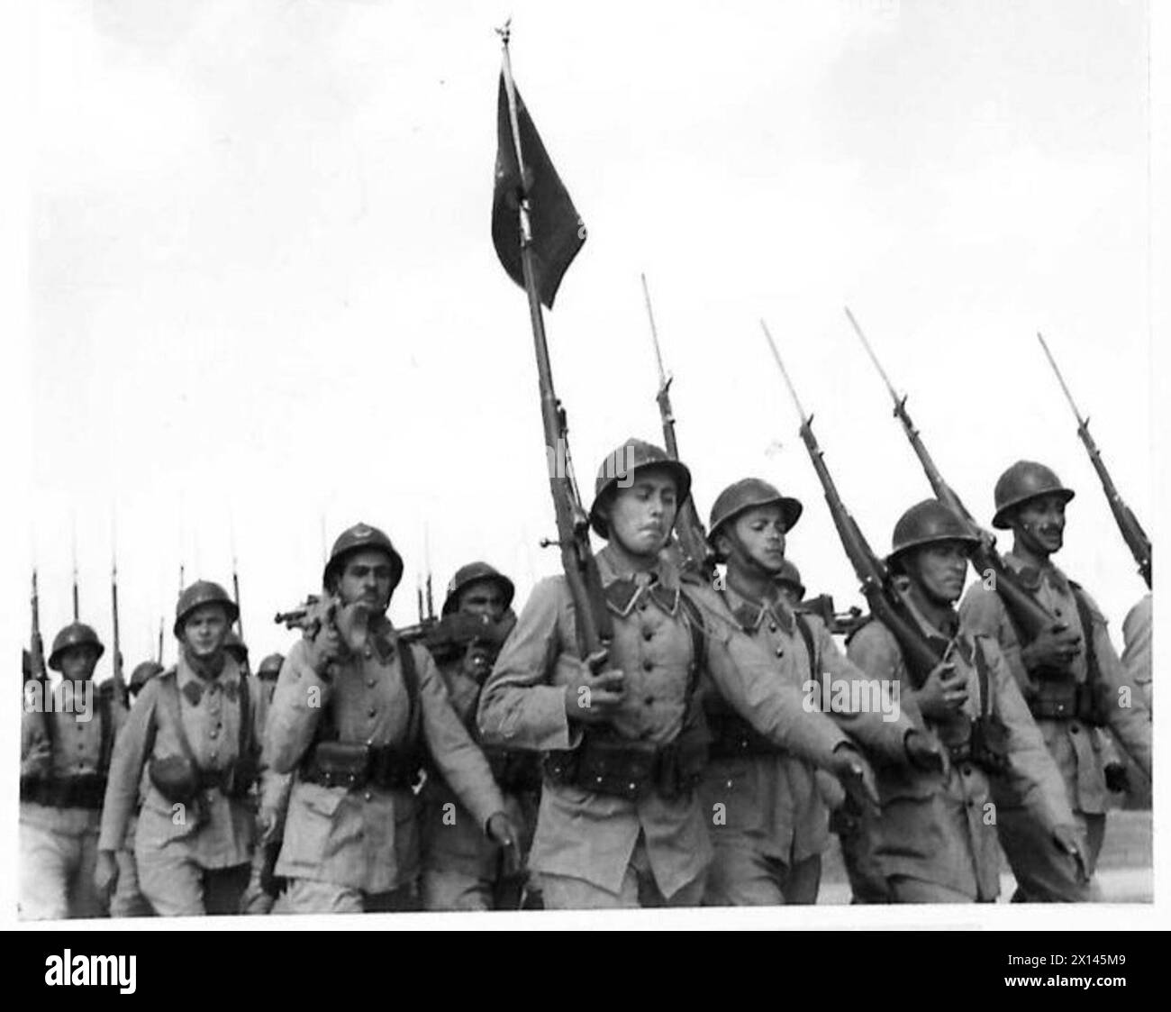 Le truppe francesi marciano davanti a sua Maestà il Re durante una revisione cerimoniale in Nord Africa. Foto Stock