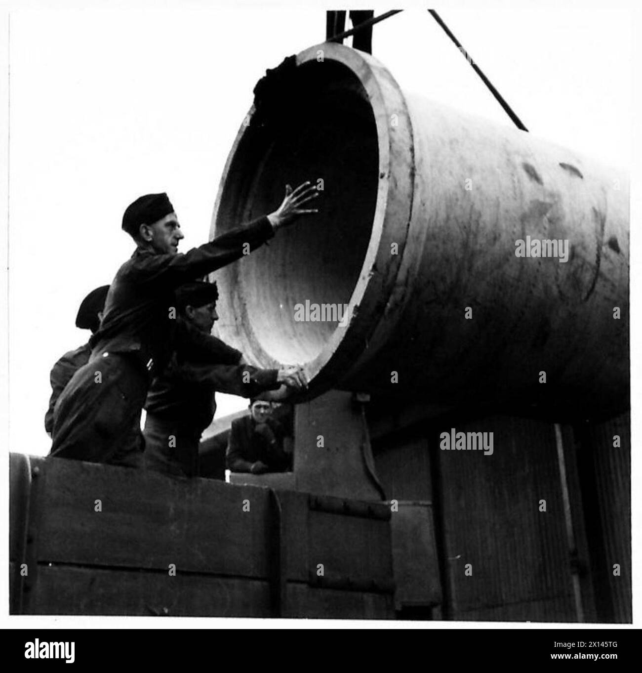 Pionieri che assistono nello scarico di tubi in cemento armato presso la banchina sotto la supervisione dell'esercito britannico. Foto Stock