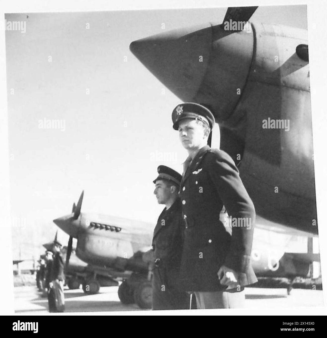 Piloti americani e francesi ispezionano un P-40 Curtiss Warhawk sotto la fusoliera a Maison Blanche, 9 gennaio 1943. Tredici P-40 furono presentati ufficialmente alla Lafayette Escadrille francese, successori del Lafayette Squadron della prima guerra mondiale Foto Stock