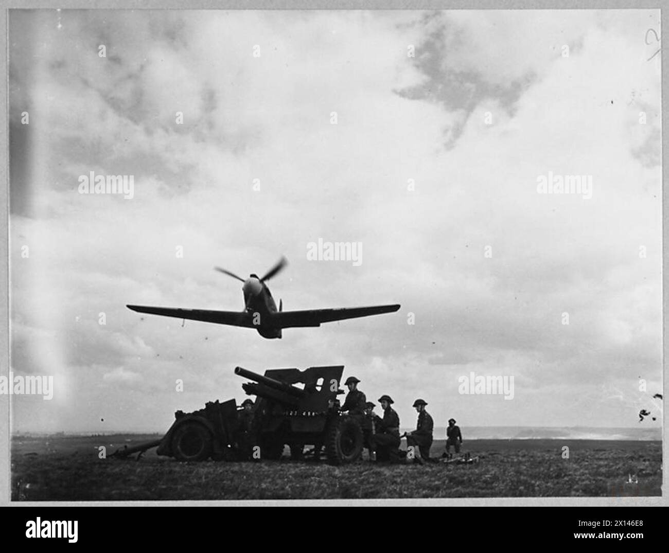 Un aereo Mustang della Royal Air Force vola a bassissima altitudine su un cannone da campo da 25 libbre, dimostrando una stretta capacità di supporto per le forze terrestri. Foto Stock