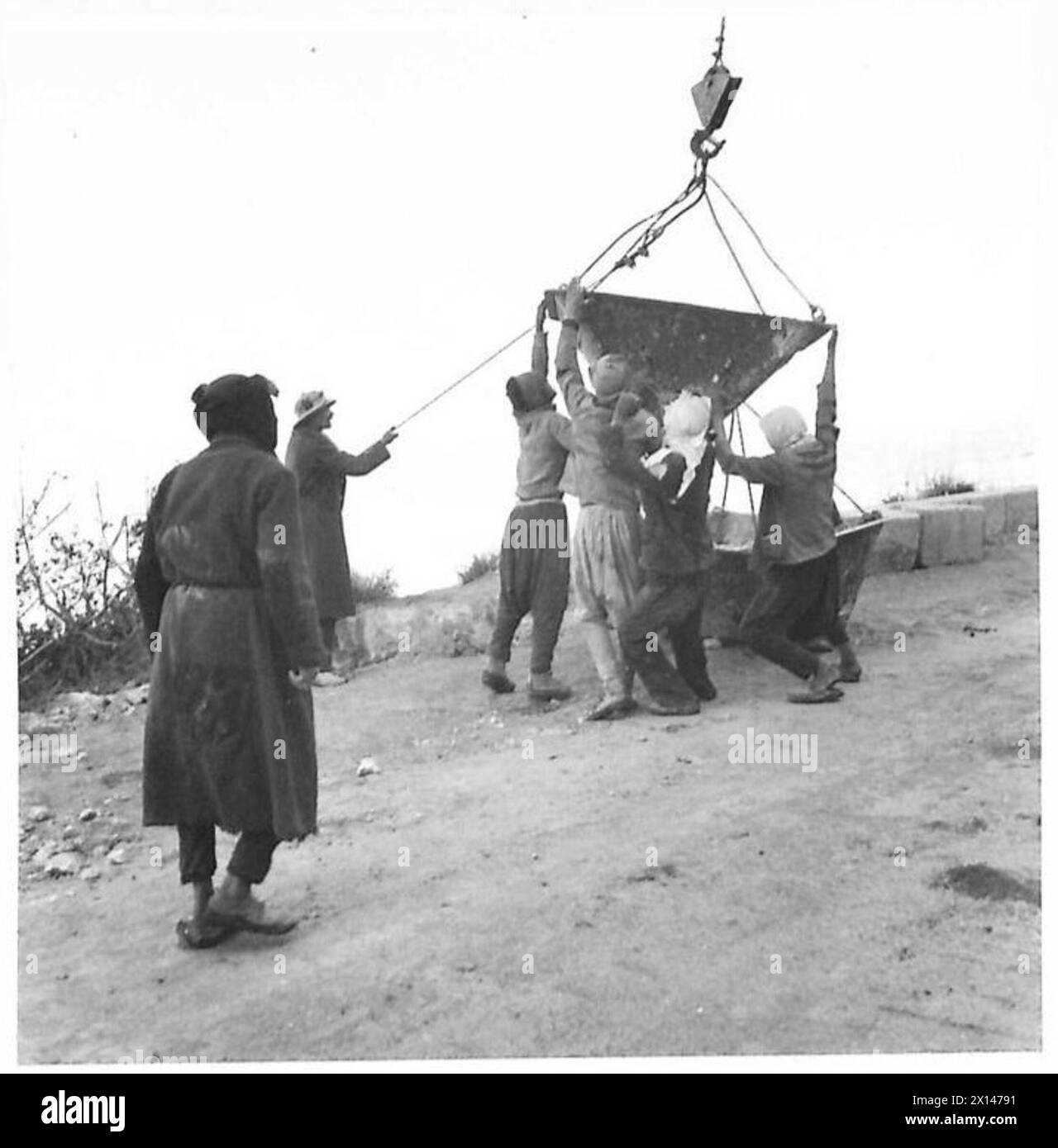 La costruzione della ferrovia Haifa-Tripoli prevedeva l'uso di una gru per posizionare pietre sopra una scogliera su una mensola per costruire un muro di contenimento. Foto Stock
