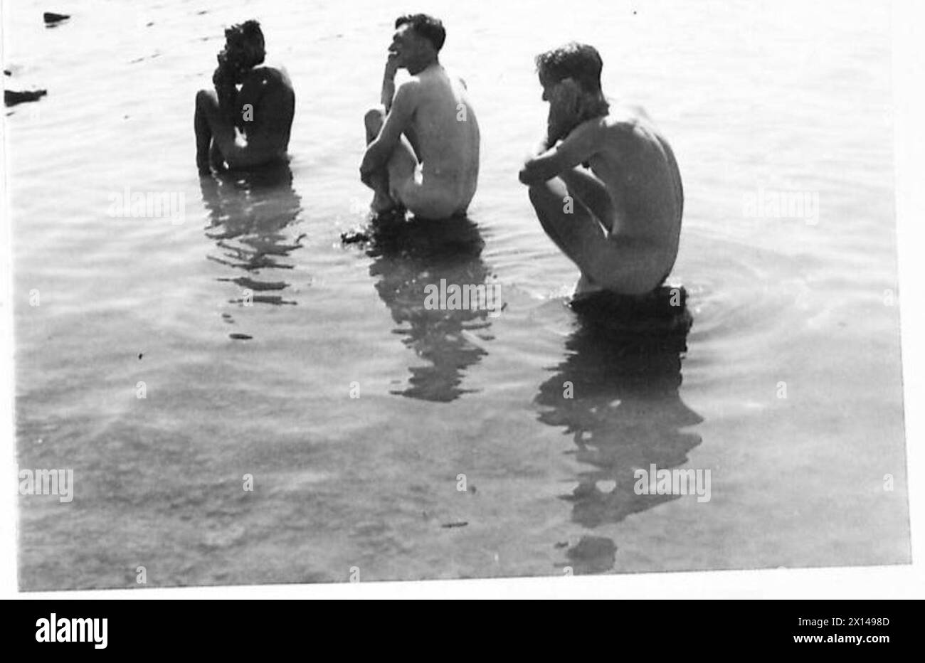 Tre soldati britannici riposano e si puliscono nel lago Trasimeno durante le operazioni dell'Ottava Armata, mentre l'estremità del lago rimane sotto il controllo tedesco. Foto Stock