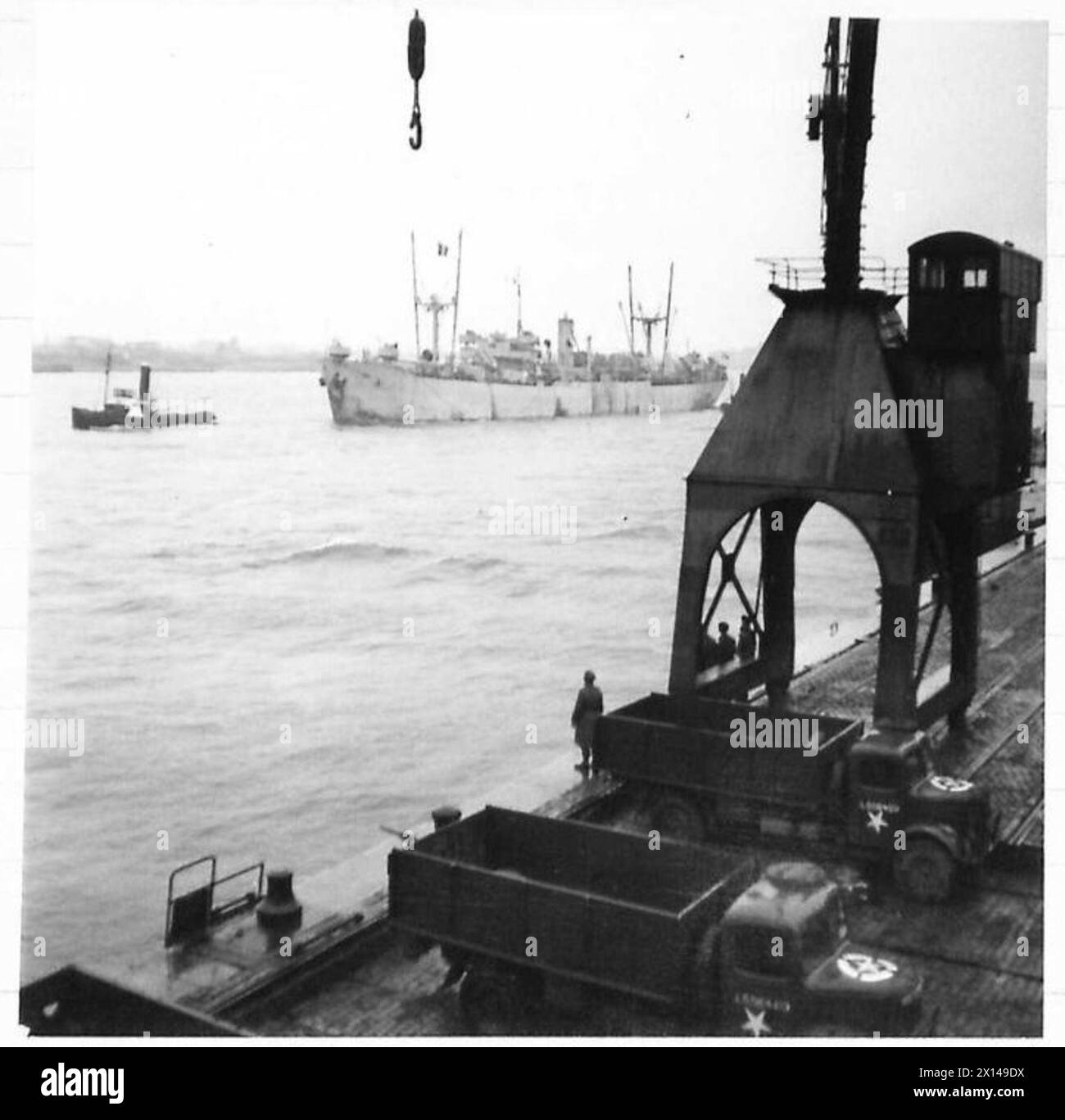 Il porto di Anversa riapre con la nave mercantile Fort-Cataraqui trainata fino all'ormeggio 22. I camion RASC sono in attesa in primo piano mentre gru e imbarcazioni navali sono posizionate sulla destra. L'operazione è supervisionata dal British Army, 21st Army Group. Foto Stock