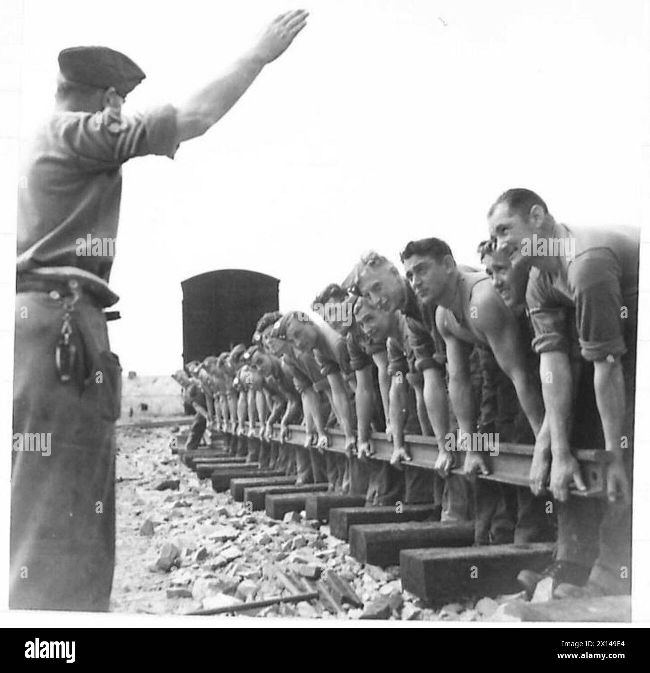 Gli arpappatori dell'esercito abbassano le rotaie ferroviarie sulle traverse durante le operazioni di costruzione o manutenzione. Foto Stock