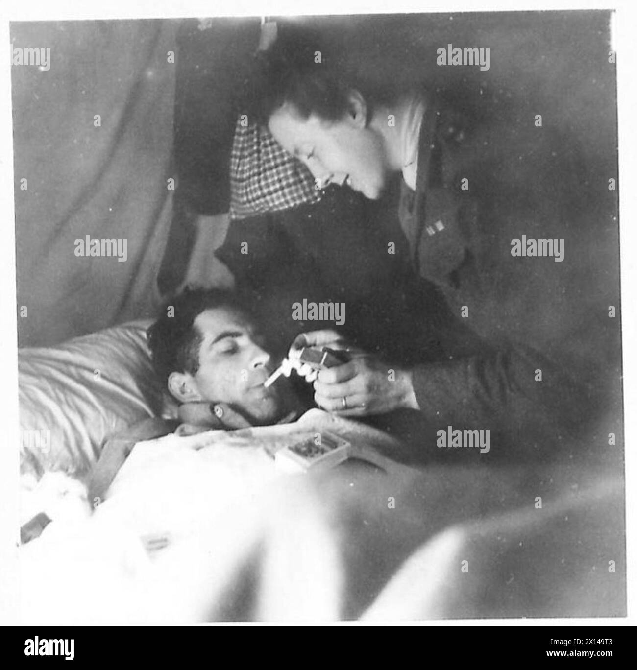 Suor Grant consegna doni della Croce Rossa al soldato ferito J. Alleker e ad altri soldati feriti, garantendo loro cura e riposo. Foto Stock