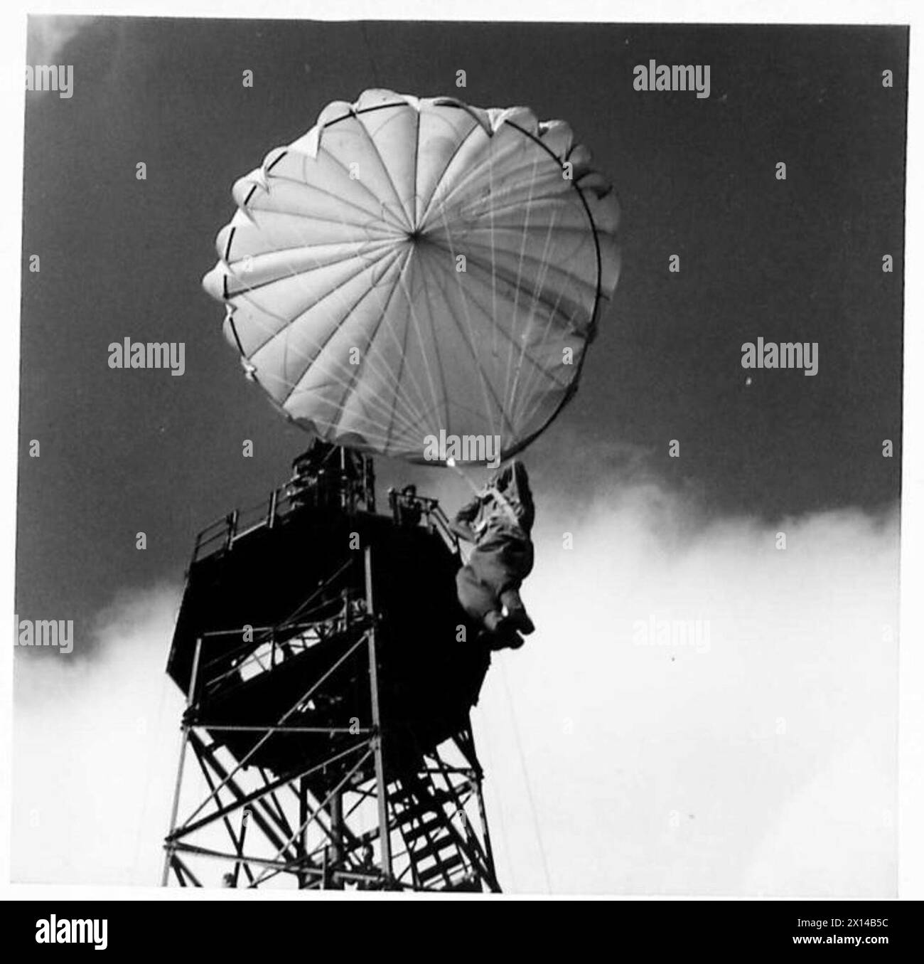 Un soldato fa una discesa controllata dalla torre del paracadute durante l'addestramento al Parachute Training Depot e alla School of Airborne Forces, British Army. Foto Stock