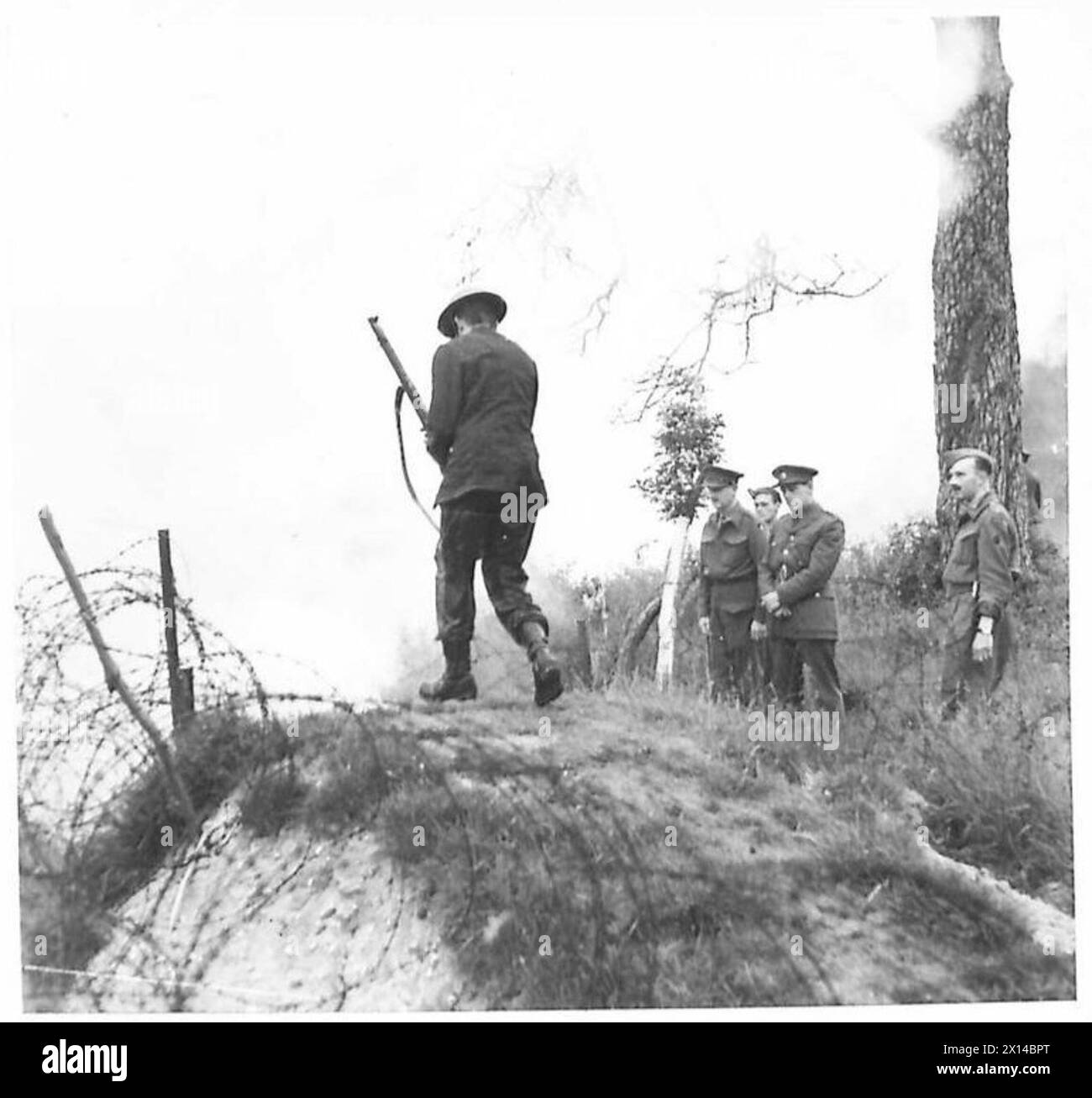 Il corrispondente di guerra russo M. Boderenkov osserva un soldato dell'esercito britannico che negozia un corso d'assalto in una scuola di addestramento da battaglia. Foto Stock