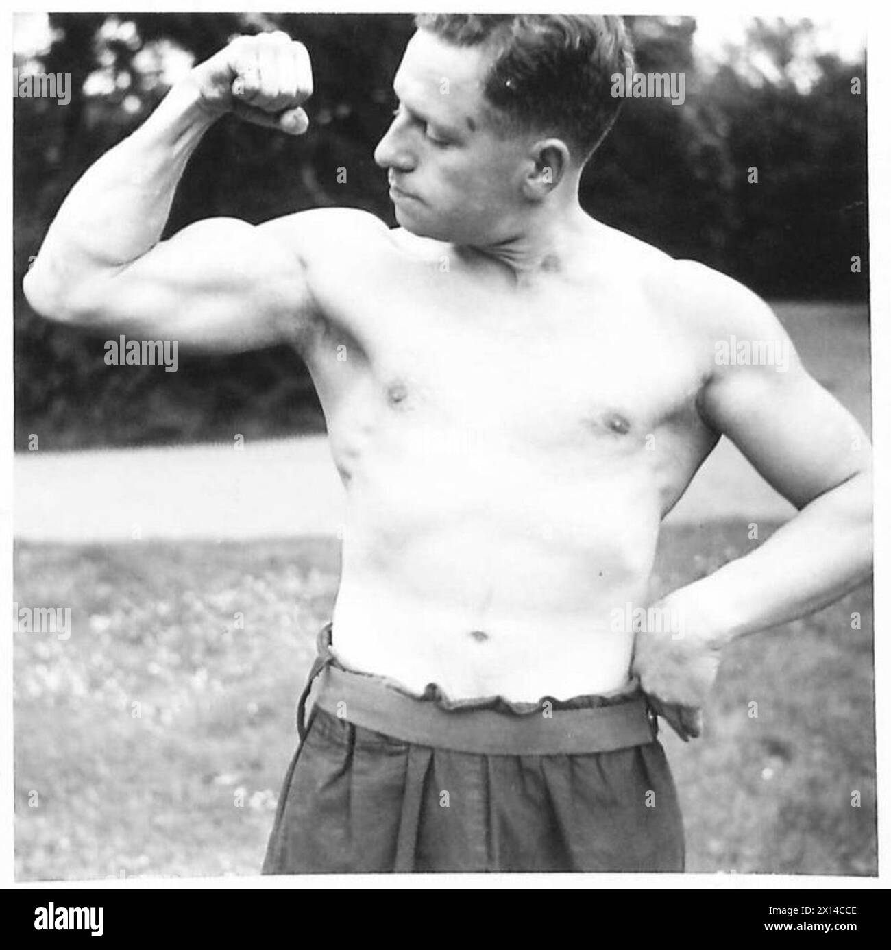 Sapper D. Lewis dell'esercito britannico, in precedenza droghiere, dimostra lo sviluppo fisico raggiunto dopo quattro anni di addestramento alla costruzione di ponti, come documentato in una serie di fotografie. Foto Stock