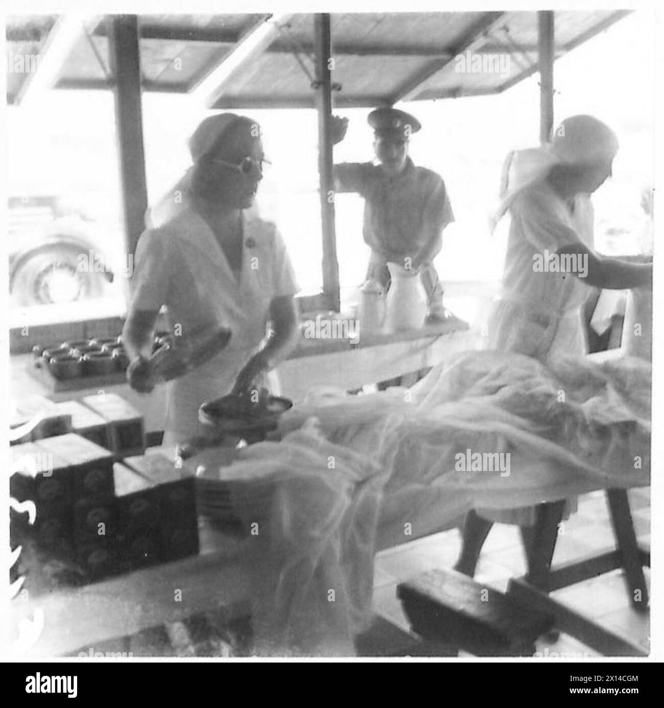 I volontari preparano cibo e bevande per le truppe in una mensa a lato della banchina. Foto Stock