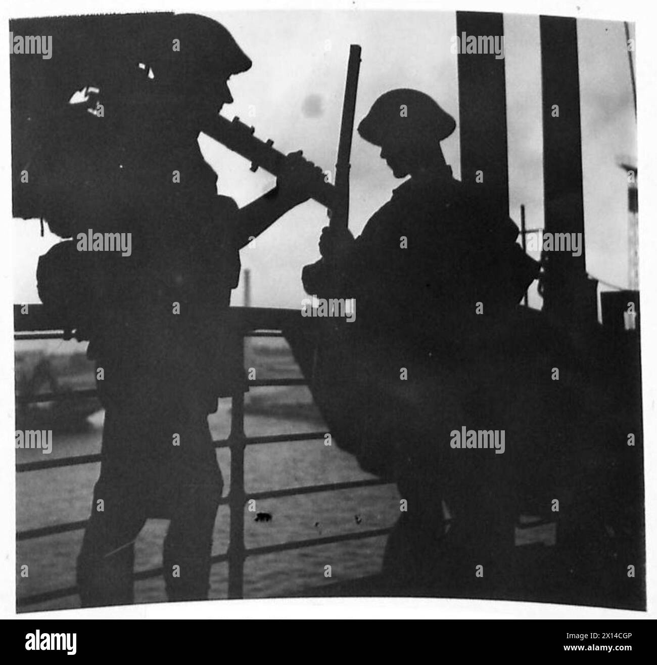 Un soldato che trasporta un mortaio da 2 pollici osserva un compagno che carica un fucile durante i test finali di atterraggio a bordo del Castello di Winchester per l'invasione della Sicilia. Foto Stock