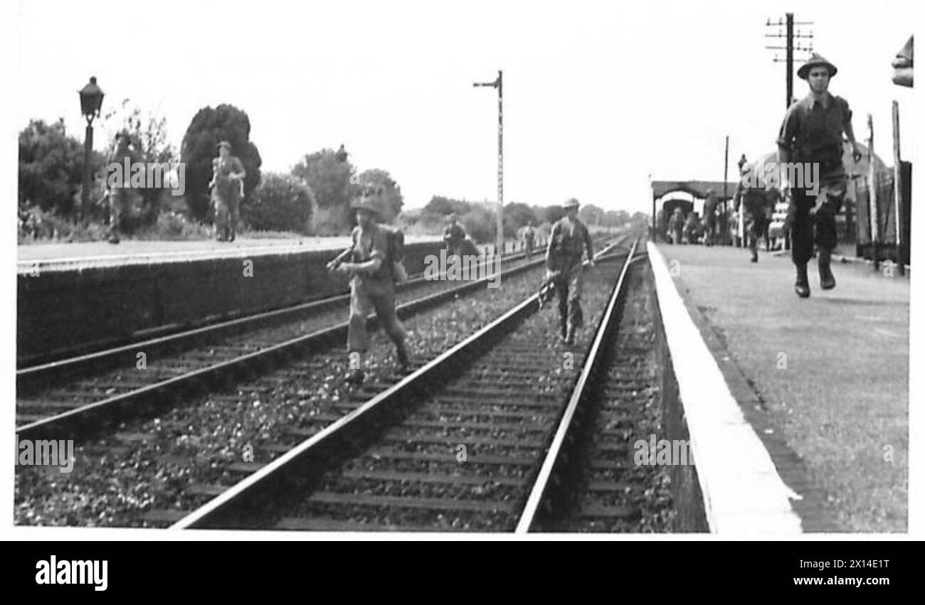 Le truppe dell'esercito britannico avanzano lungo un binario ferroviario dopo aver completato un'esercitazione che comporta la bonifica di una stazione di forze opposte. Foto Stock
