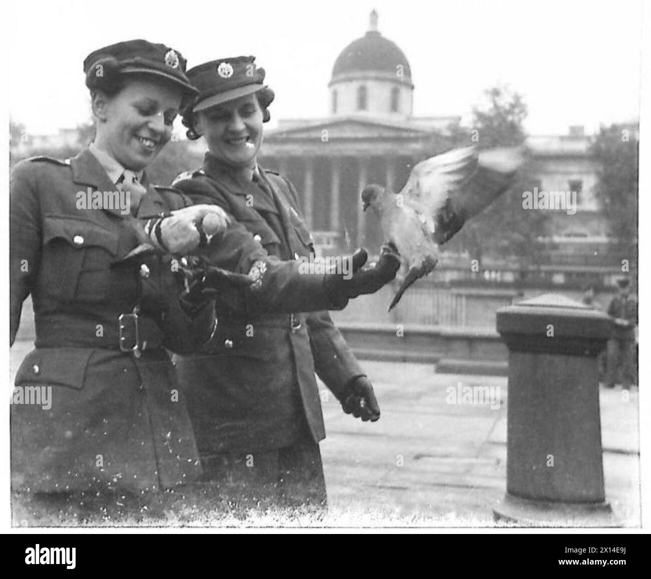 Le sorelle sergenti maggiori visitano Trafalgar Square a Londra. Osservano i piccioni e interagiscono con il pubblico mentre visitano il centro di Londra durante la loro giornata fuori. Foto Stock
