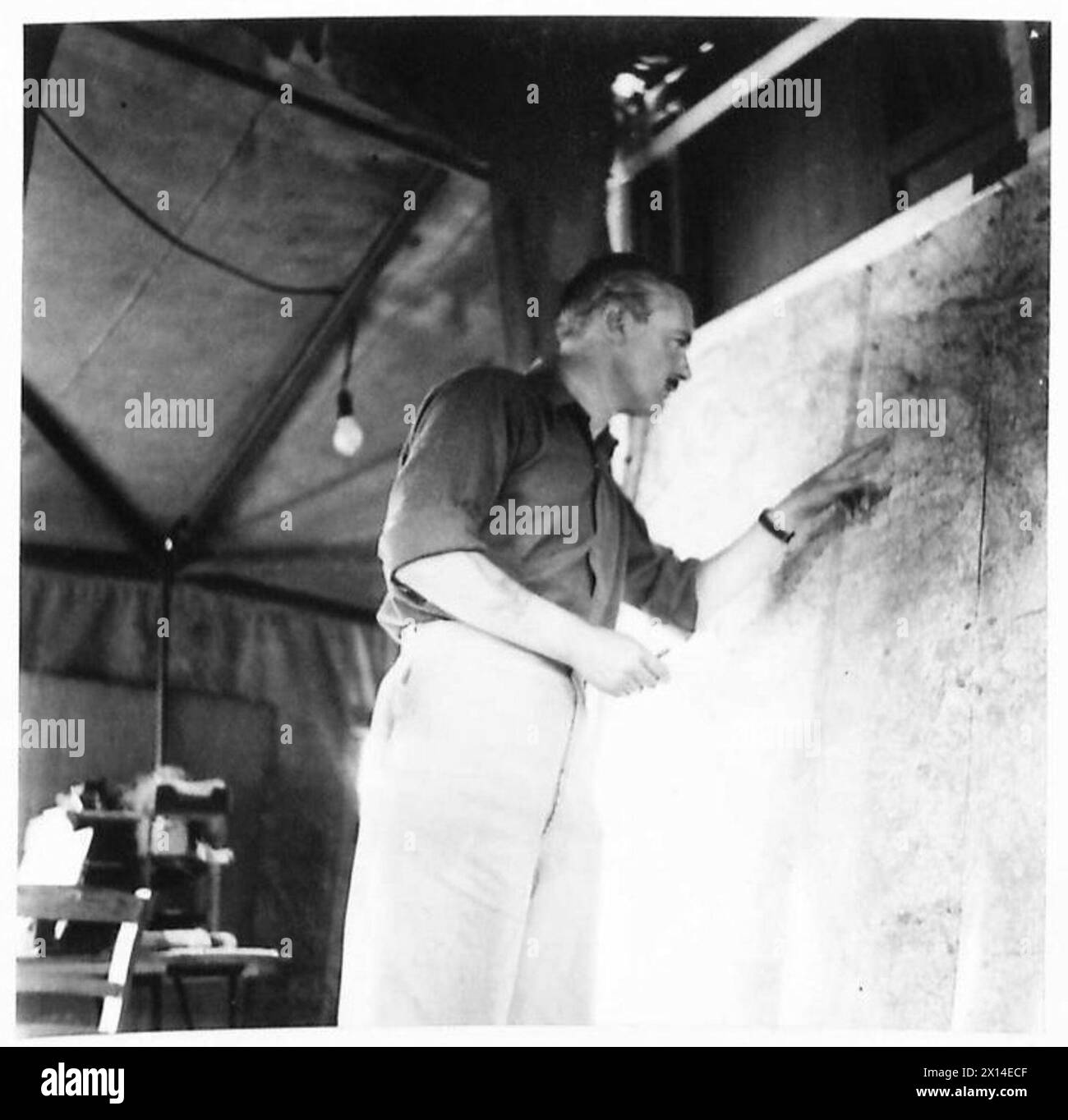Il capitano H.A.G. Williams esamina i dettagli operativi sulla mappa Phantom Operations prima di trasmettere un messaggio al 21st Army Group, parte delle attività dell'esercito britannico. Foto Stock
