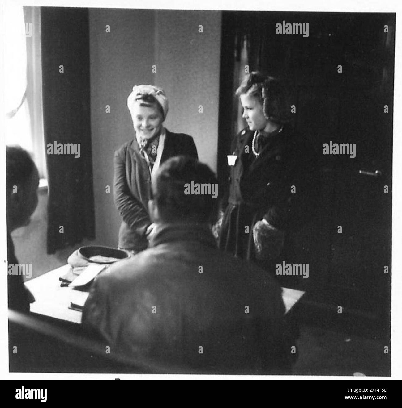 Due ragazze civili tedesche sono interrogate sotto la supervisione del governo militare dall'esercito britannico, 21st Army Group. Foto Stock