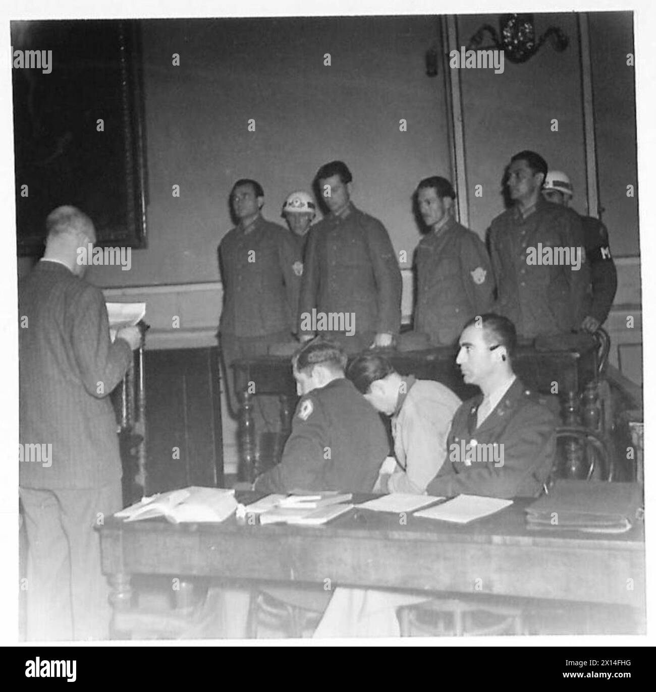 Durante un processo per criminali di guerra, l'interprete barone Arnould Franchetti lesse le accuse agli imputati sotto la supervisione dell'esercito britannico. Foto Stock