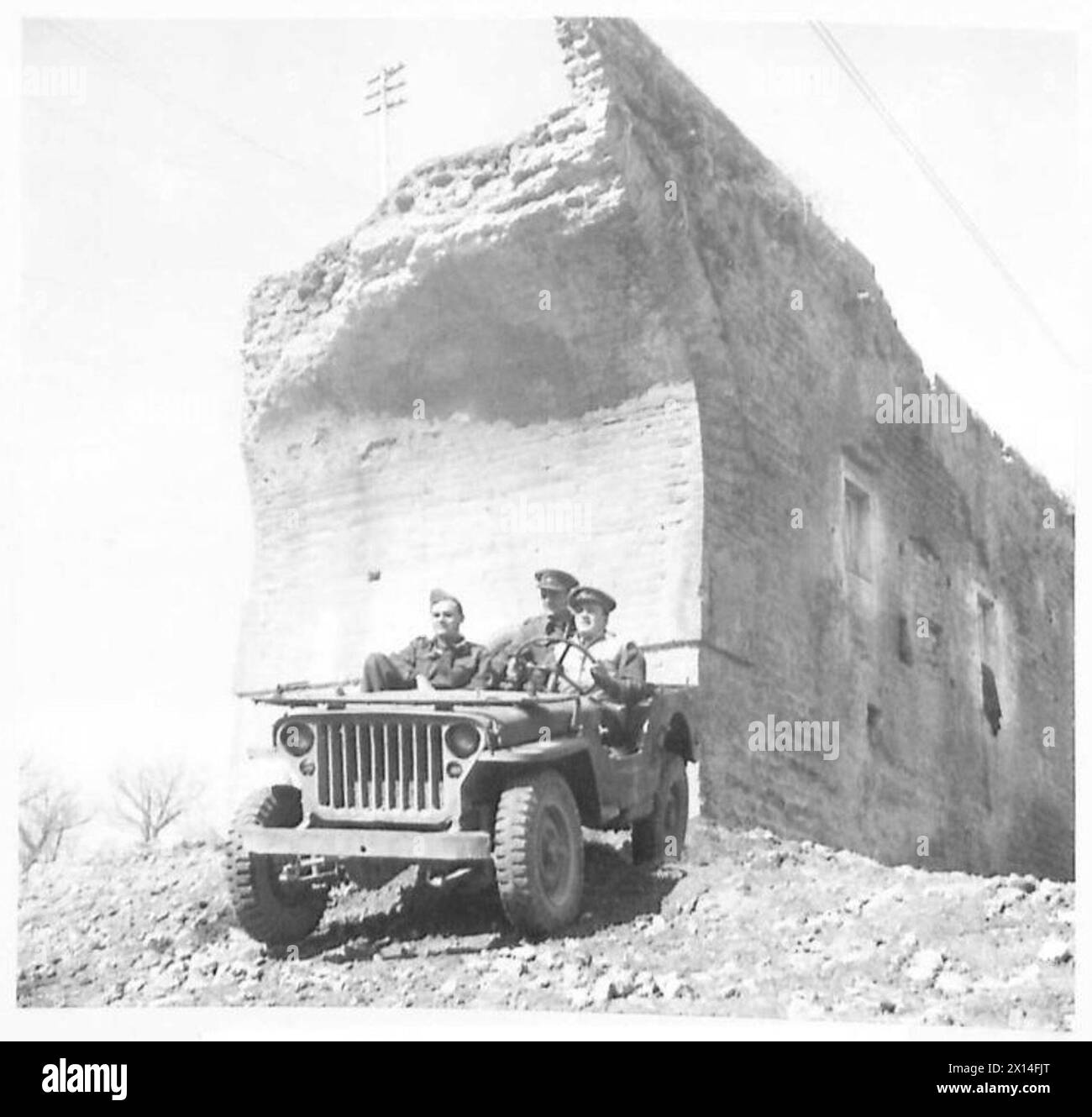 Una jeep trasporta i corrispondenti Reginald Beckwith, Dom Campbell e Ab Hammond lungo una strada sterrata verso il fronte durante le operazioni dell'esercito britannico in Nord Africa, Sicilia, Italia, Balcani e Austria tra il 1942 e il 1946. Foto Stock