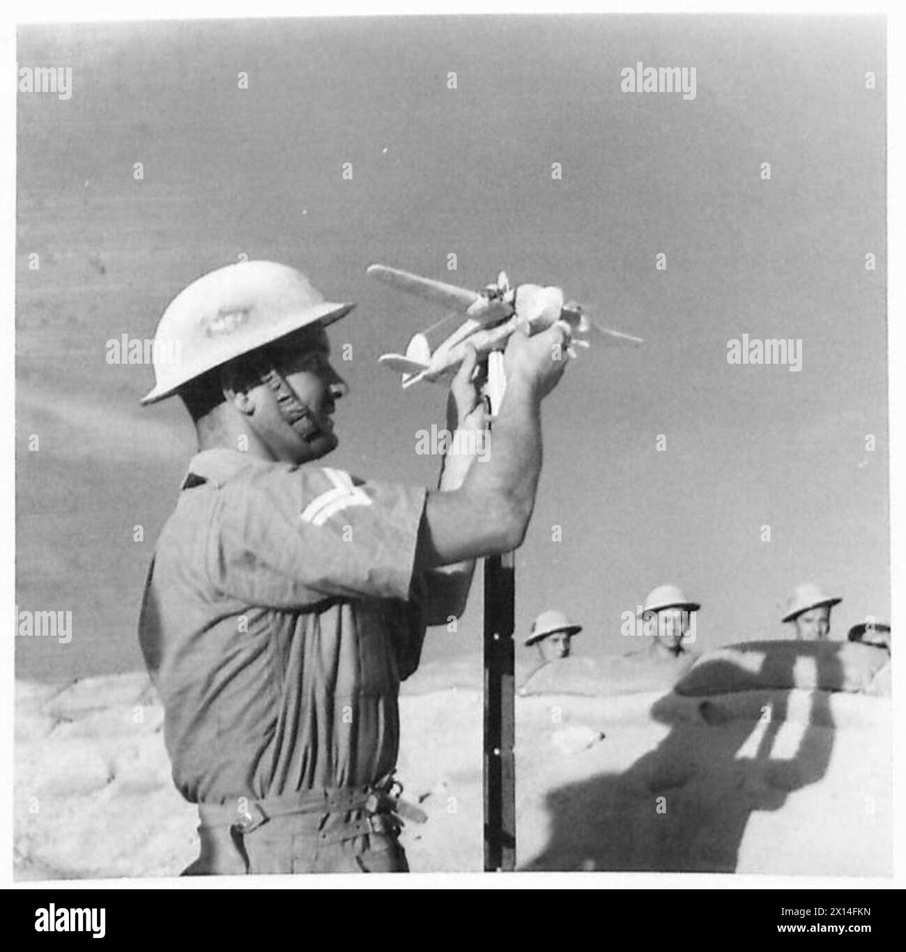 Un caporale incide modellini di aeroplani durante il periodo di inattività tra un'azione e l'altra nel deserto occidentale, catturati da un fotografo ufficiale dell'esercito britannico. Foto Stock