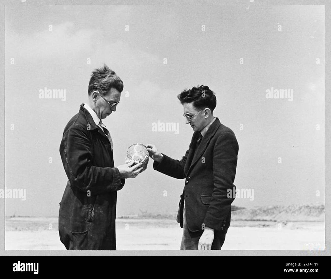 Una fotografia del 1944 che mostra il signor Grimes che presenta un'antica ciotola di ceramica al signor F.R. Martin in un campo di aviazione della RAF di recente costruzione, evidenziando la scoperta di un sito archeologico pre-romano. Foto Stock