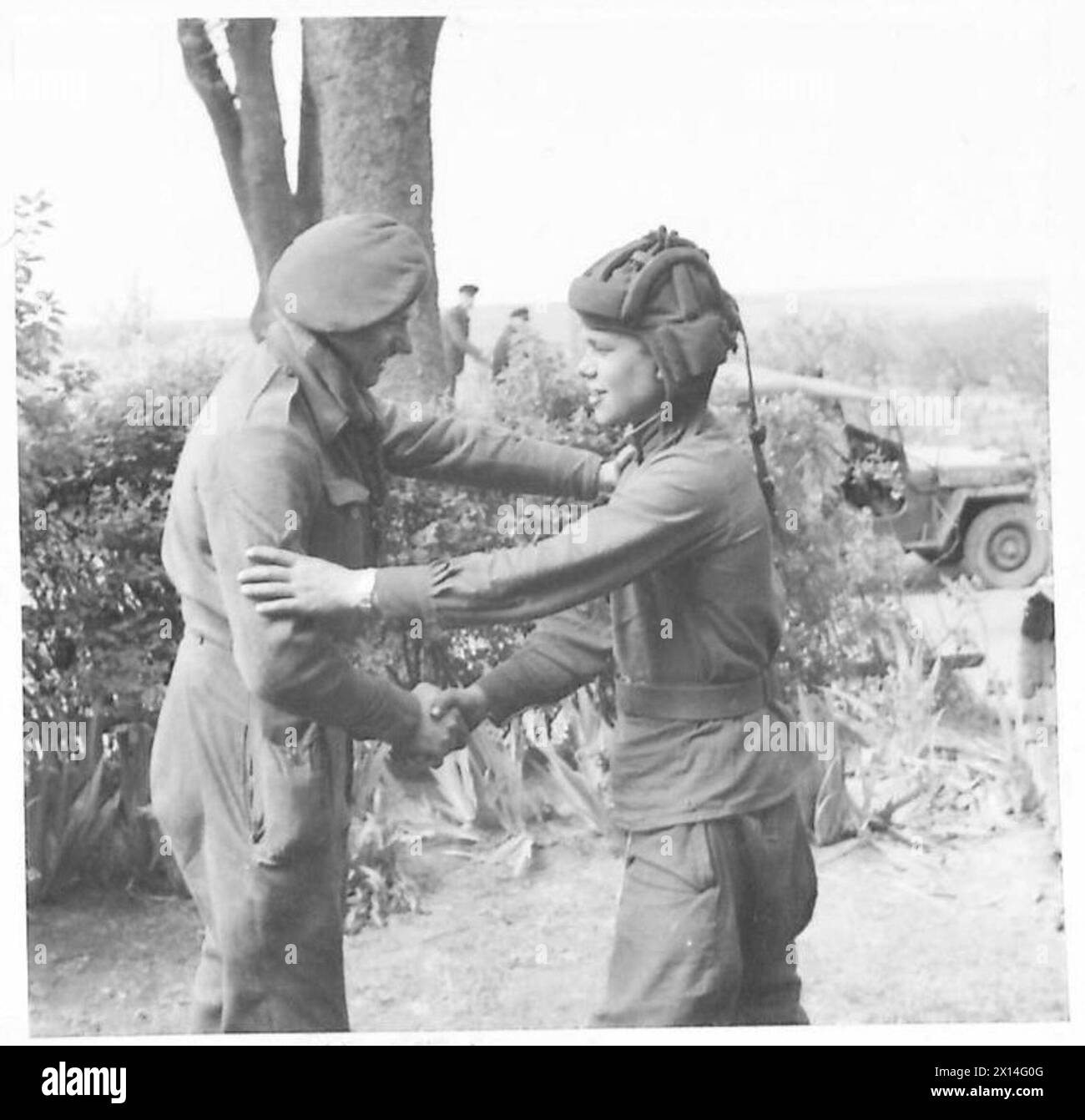 Lance Bombardier E. Manley MM dell'esercito britannico saluta un membro dell'equipaggio dei carri armati russi durante il collegamento alleato in Europa. Foto Stock