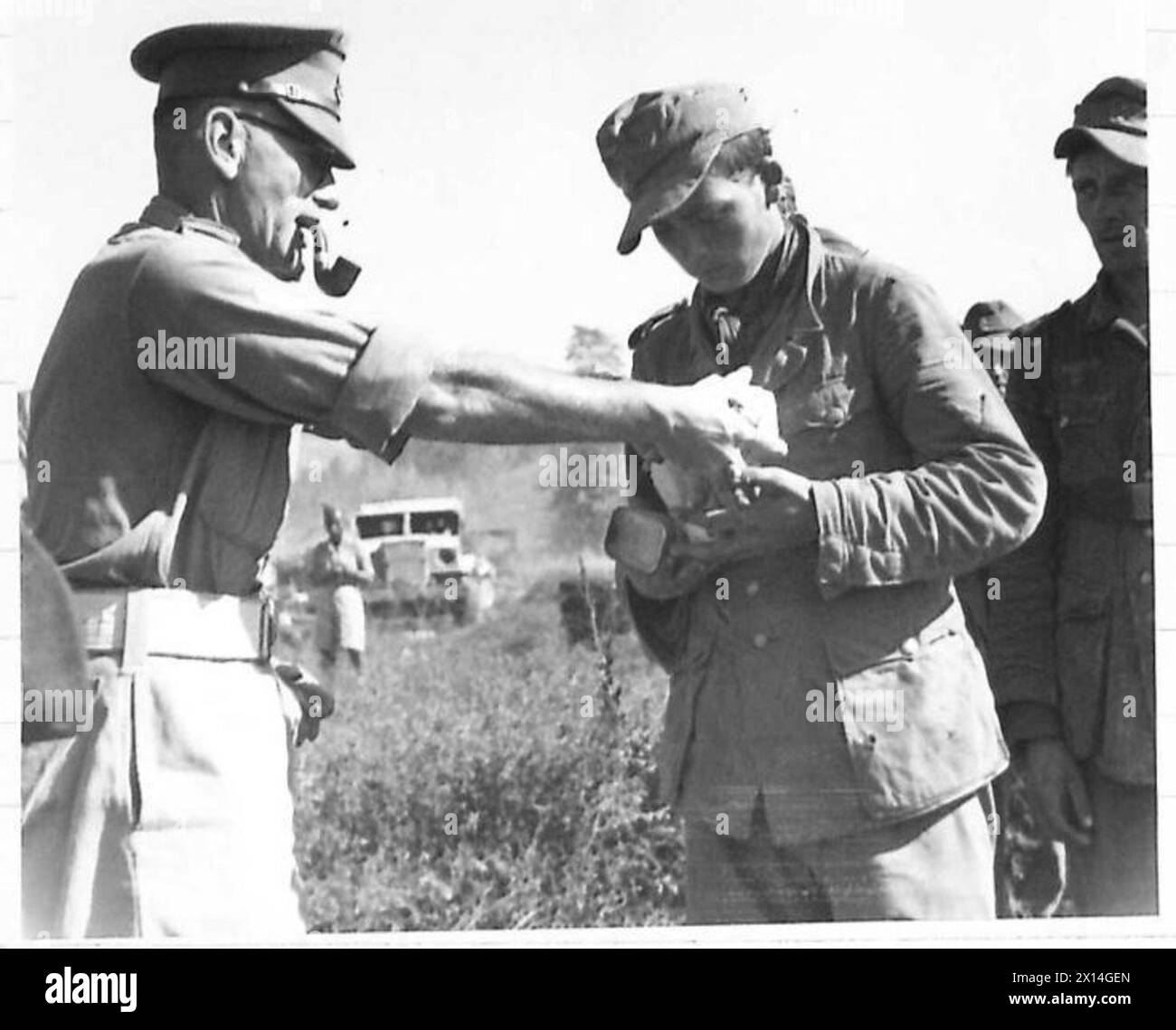 Il caporale Lance Nind della 4th Indian Division CMP distribuisce le razioni ai prigionieri mentre entrano nella gabbia durante le operazioni dell'Ottava Armata. Foto Stock