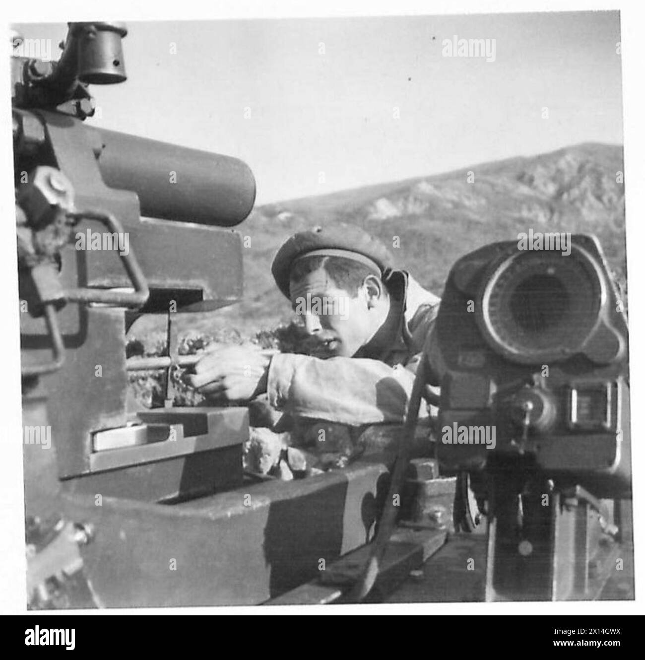 S/Sgt. Pat McCarthy, un soldato regolare dell'Ottava Armata, è raffigurato per misurare il tunnel di un cannone antiaereo da 3,7 pollici dopo il servizio in Nord Africa, Sicilia e Italia, comprese le operazioni post-D-Day. Foto Stock