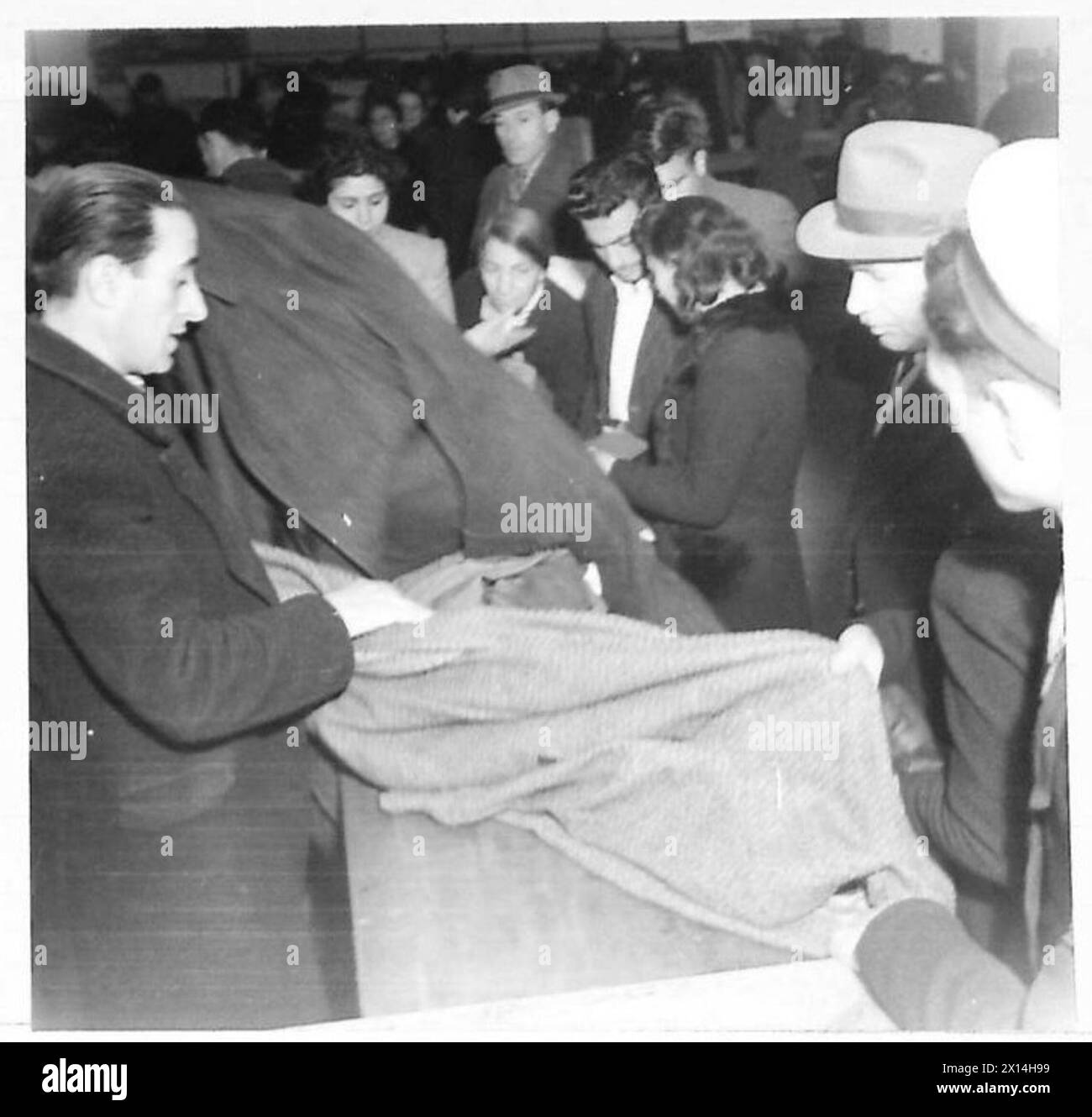 L'abbigliamento viene distribuito ad un gruppo di uomini ad Atene, che selezionano le tute che indosseranno sotto la supervisione dell'esercito britannico. Foto Stock