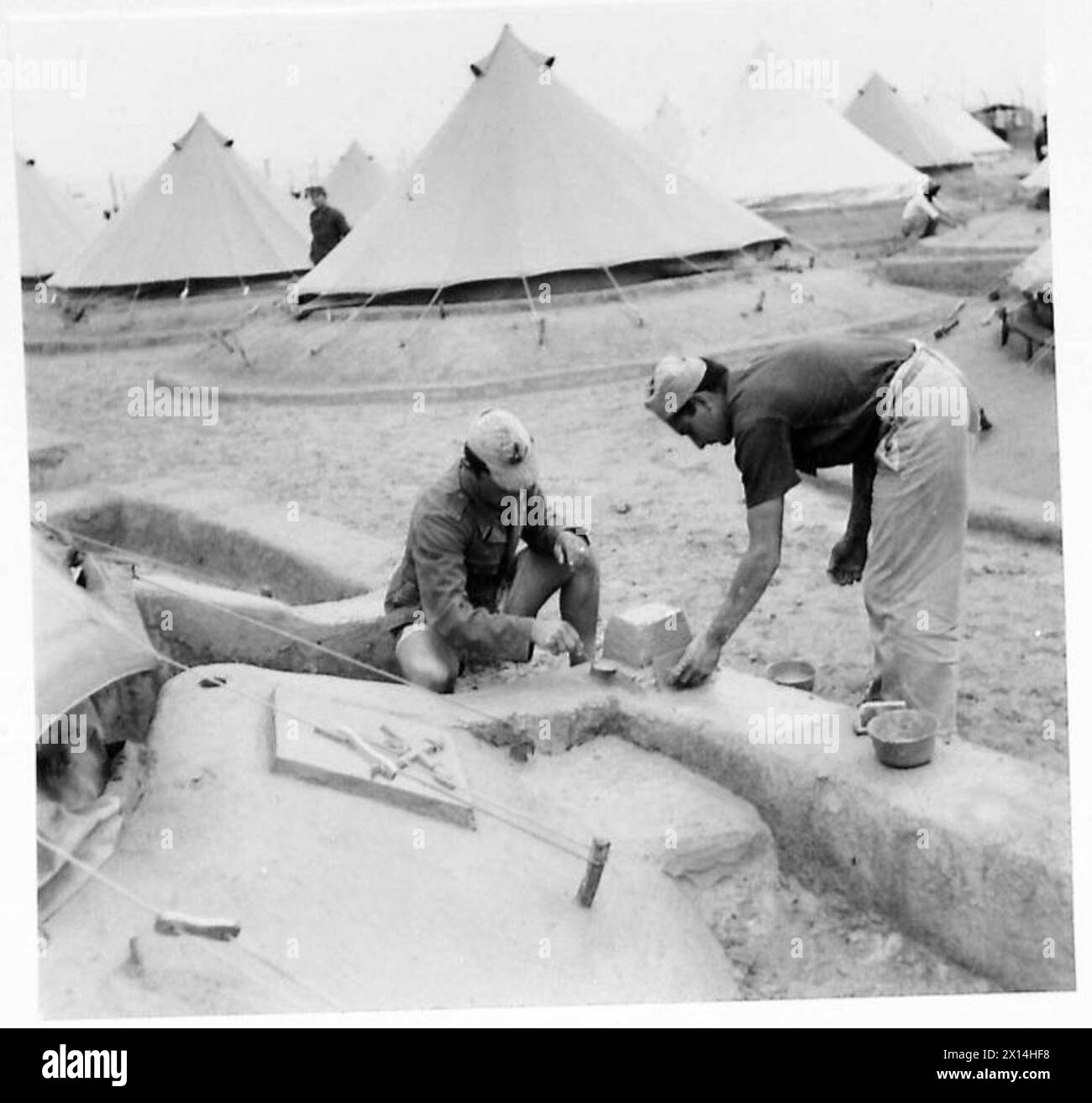 Due prigionieri stanno creando opere d'arte decorative intorno alle loro tende in un campo di prigionia, il British Army. Foto Stock