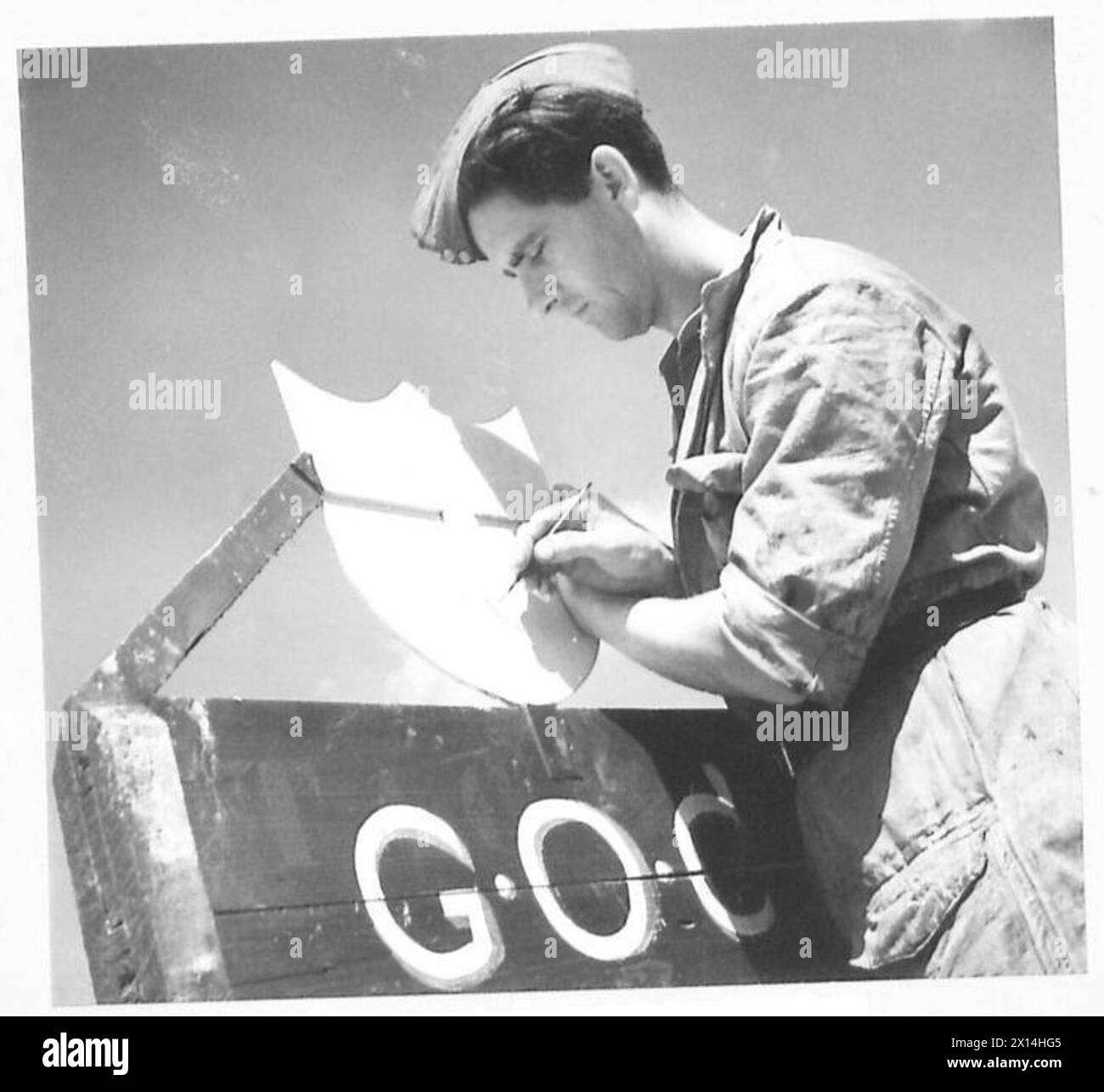 Pte. E. Price dipinge uno scudo dell'VIII Esercito in una sezione officina del campo dello Stato maggiore in Italia Foto Stock