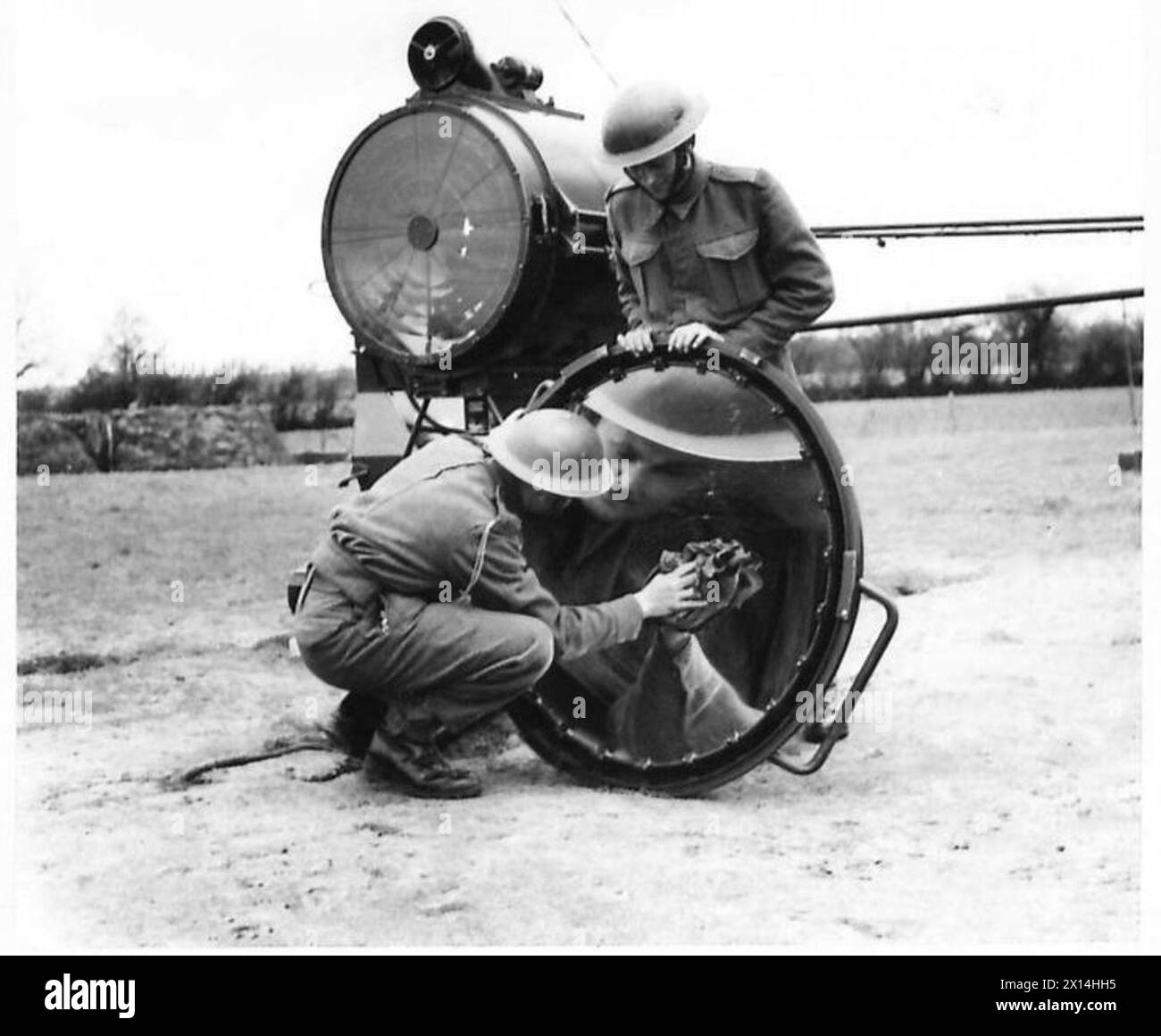 I membri di una sezione di proiettori puliscono il grande riflettore come parte della manutenzione operativa, British Army. Foto Stock I membri di una sezione di proiettori puliscono il grande riflettore come parte della manutenzione operativa, British Army. Foto Stock