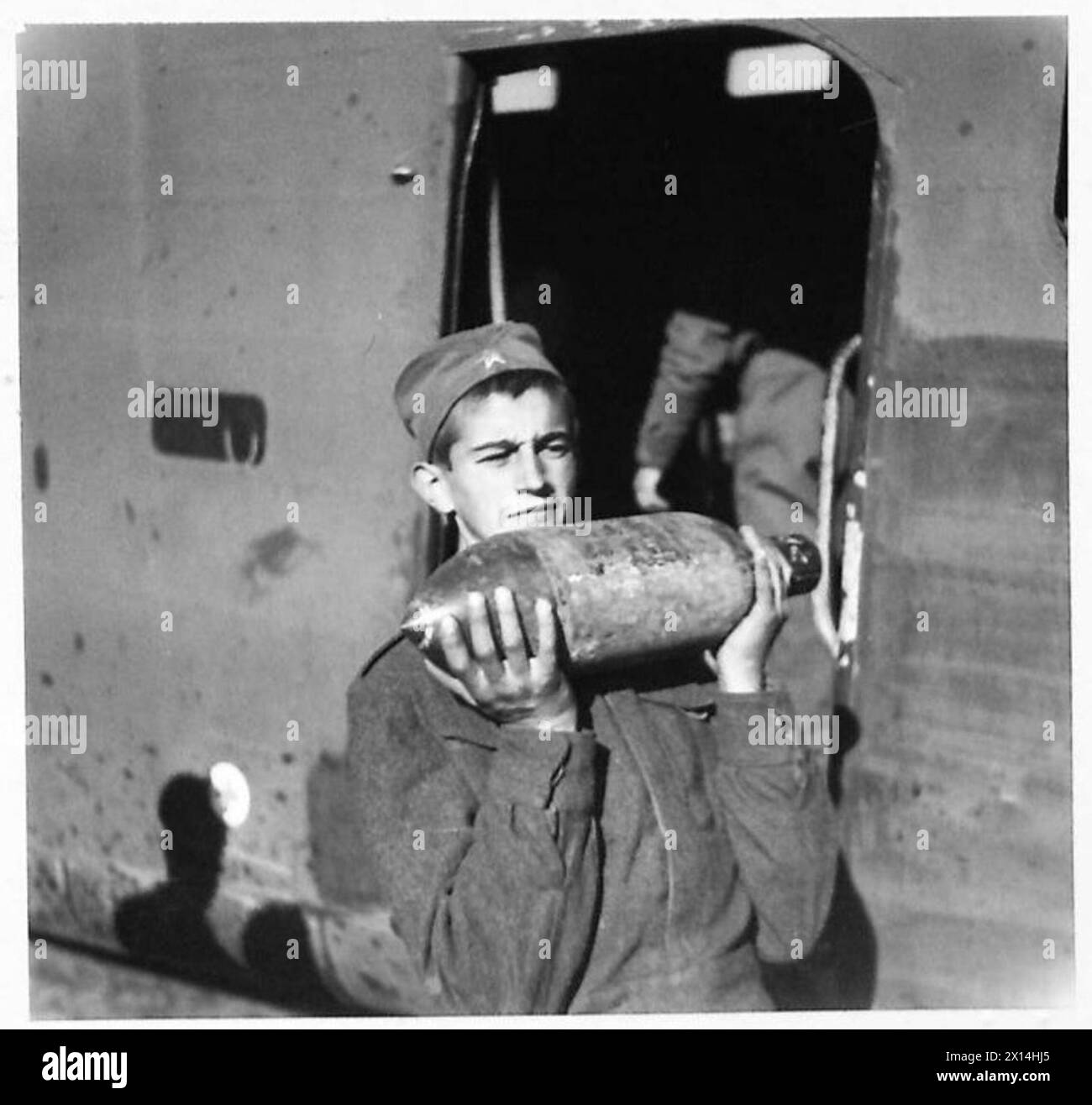 Le truppe partigiane in Jugoslavia scaricano aerei da trasporto che trasportano razioni, cannoni Bren e teste razzi per aerei che sparano razzi. Foto Stock