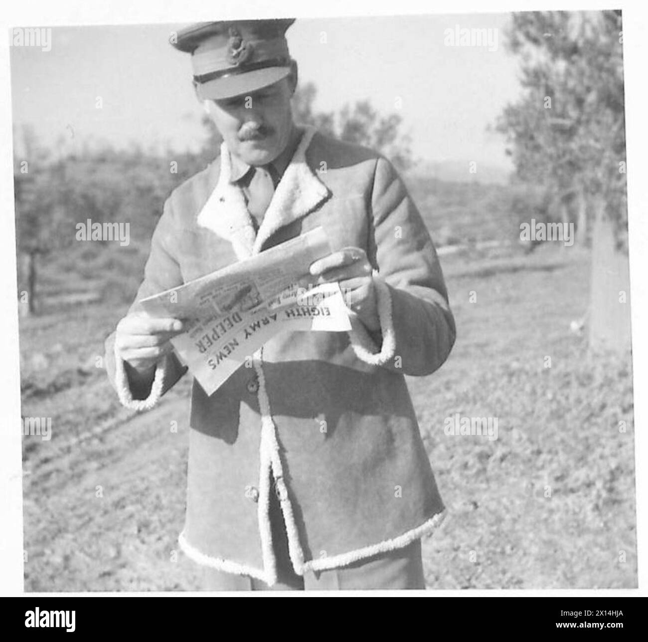 Il generale Sir Oliver Leese dell'Ottava Armata è visto leggere il "8th Army News" durante una pausa dai doveri ufficiali. Foto Stock