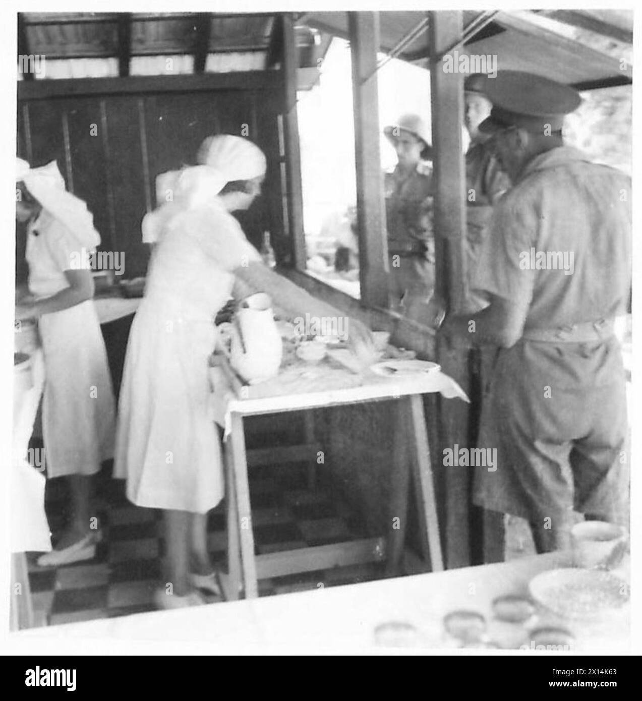 I lavoratori volontari forniscono cibo e bevande ai soldati in una mensa sulla banchina gestita dall'esercito britannico. Foto Stock