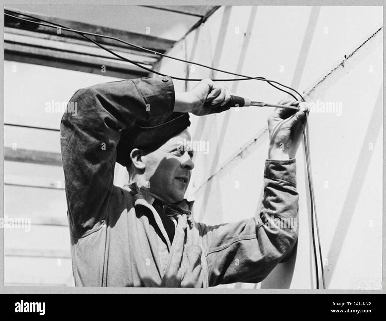 ADDESTRAMENTO POST-BELLICO IN UNA STAZIONE R.A.F. - il principale Aircraftman J. Evans di Cynfil Maes Square, Pwllheli, installando cavi elettrici nell'edificio della Royal Air Force Foto Stock